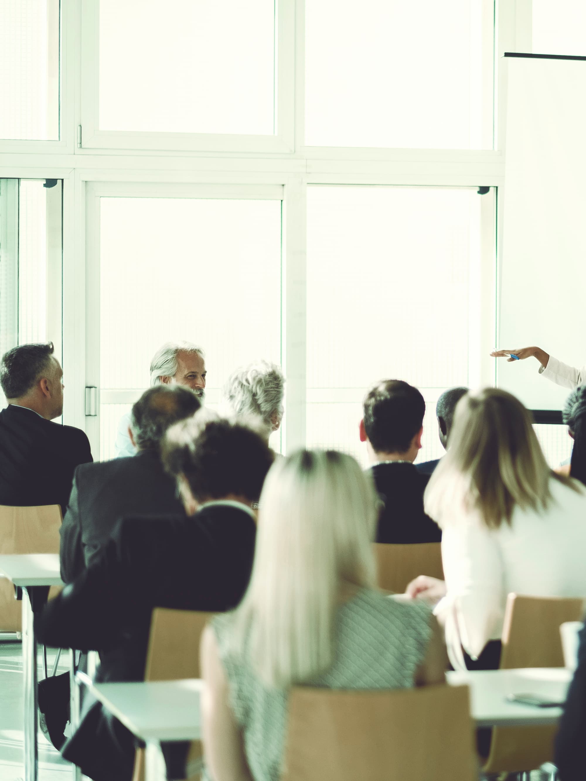 Karrieremöglichkeit “Referent:in Prävention und Gesundheitsförderung": Referentin hält Vortrag im Seminarraum