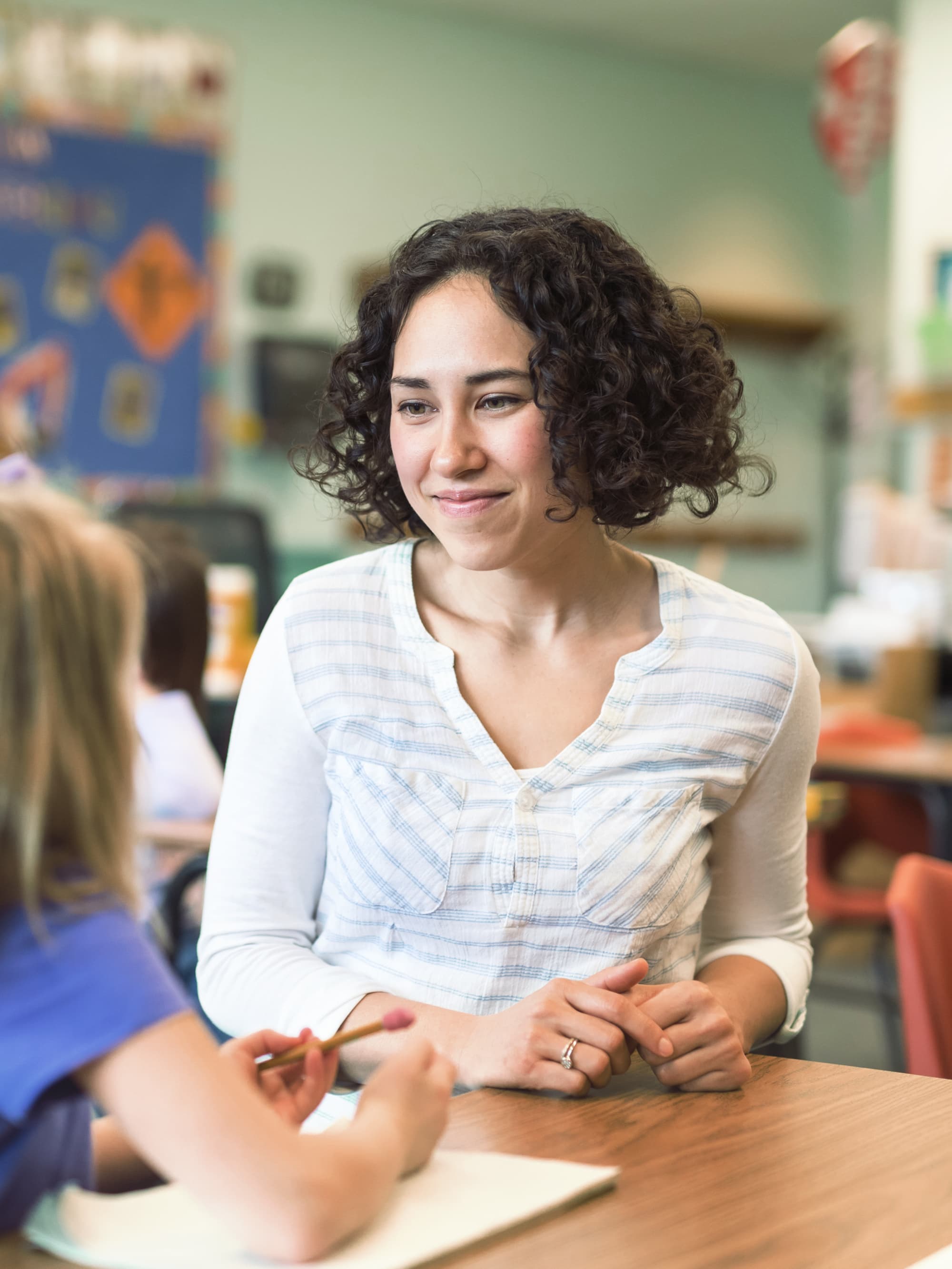 Titelbild für Studiengangseite duales Studium Kindheitspädagogik: Pädagogin mit Kind in Schule, AI-generated