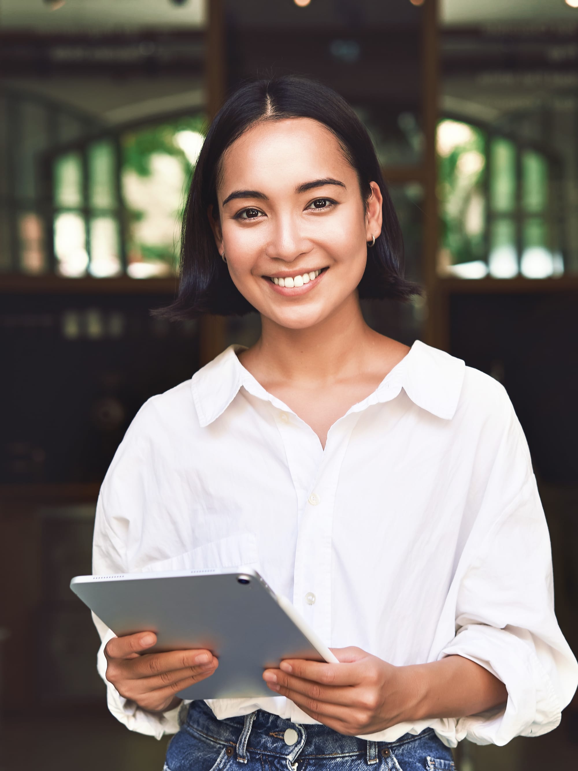 Titelbild für Studiengangseite "duales Studium Tourismusmanagement": Frau mit Tablet in Hotel, AI-generated