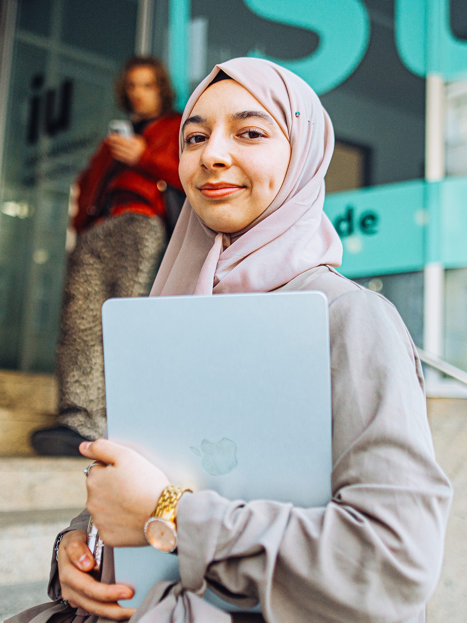 IU student smiling and holding a laptop in her hands