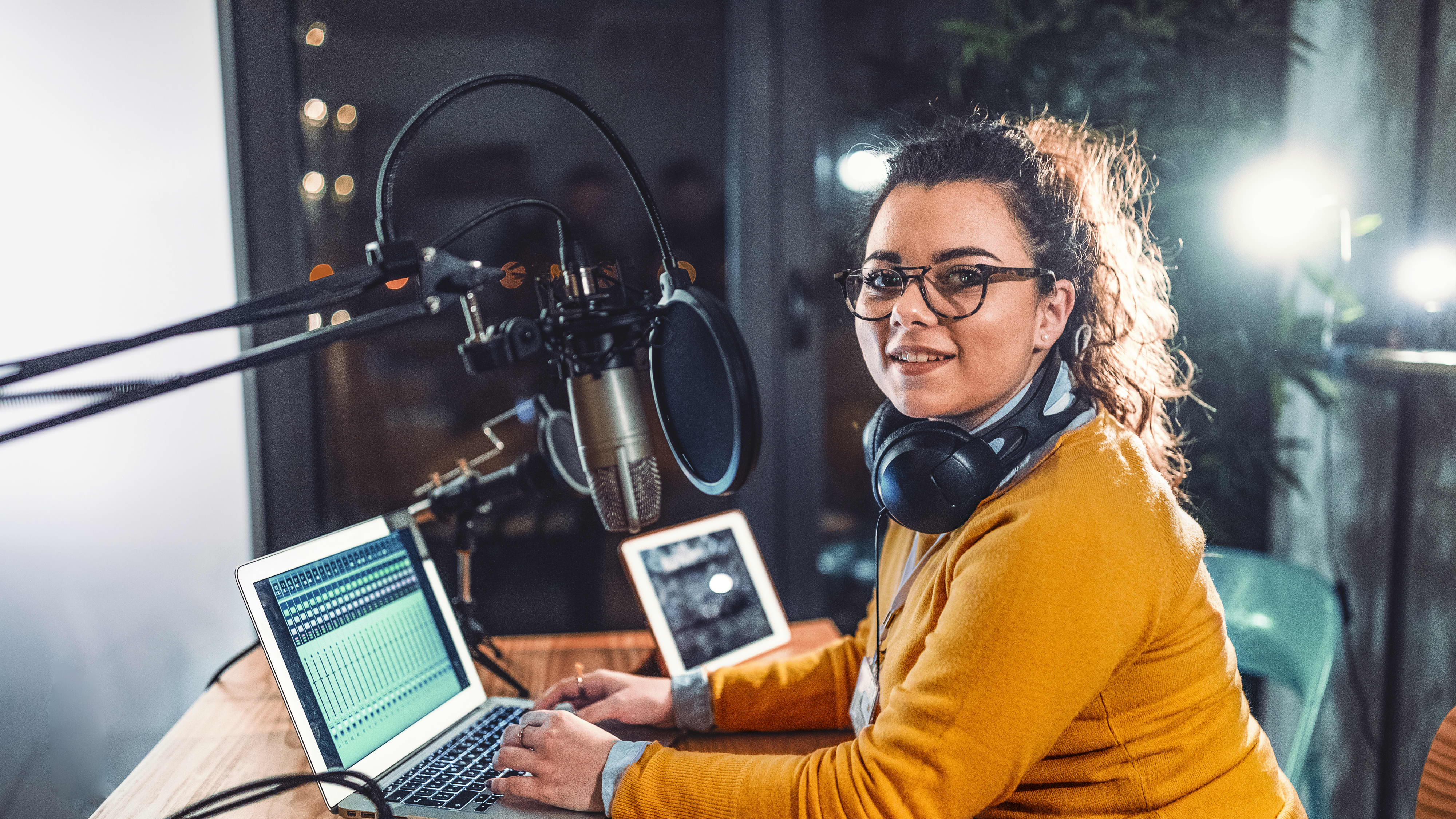 Titelbild für Infoseite “duales Studium Kommunikation und PR": Studentin mit Kopfhörern im Aufnahme-Studio