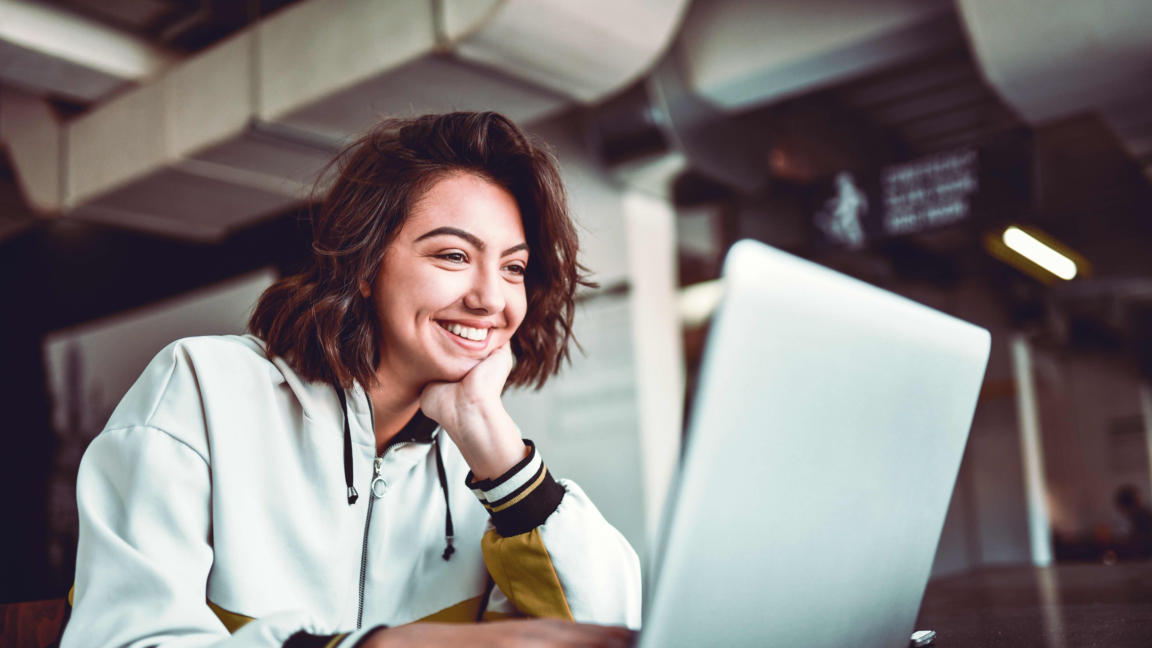 Studieninteressierte informiert sich am Laptop über Zulassung und Studienstart