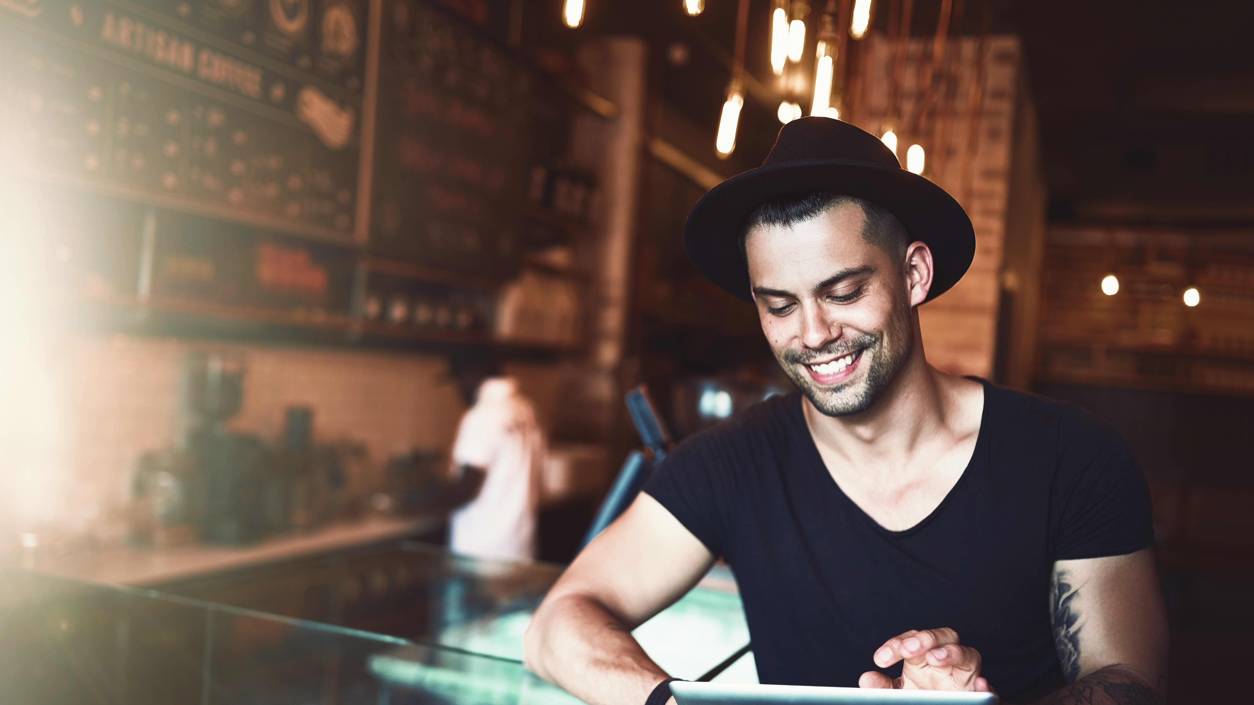 Titelbild für Studiengangseite duales Studium Food Management: Mann an Bar mit Tablet