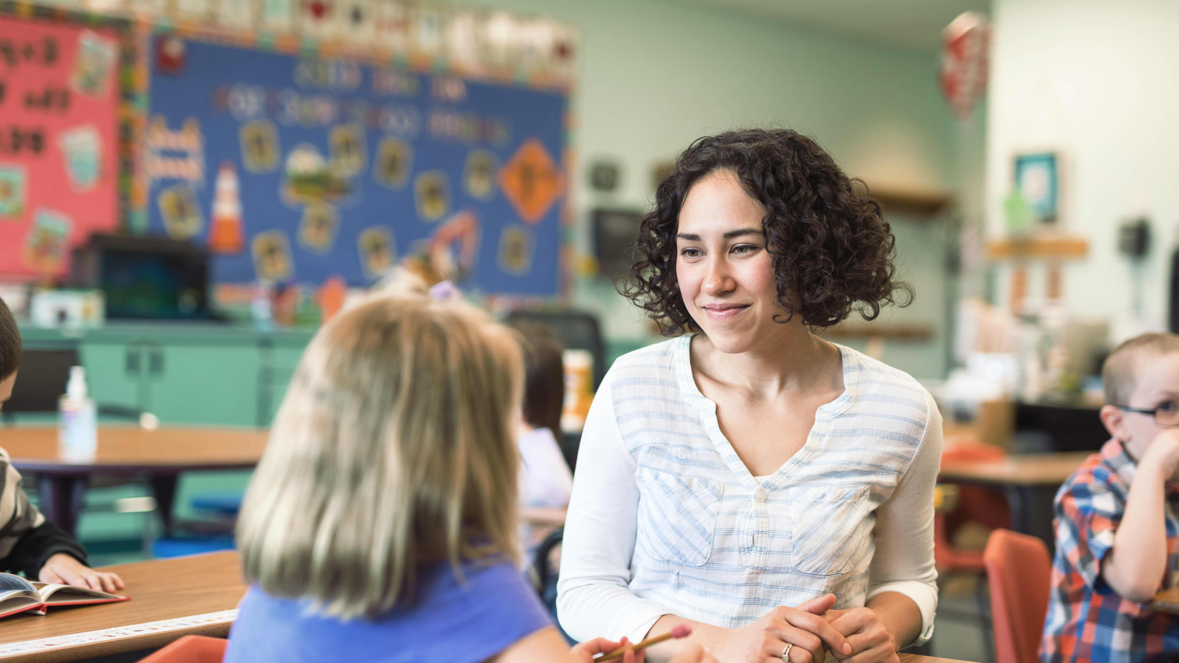 Titelbild für Studiengangseite duales Studium Kindheitspädagogik: Pädagogin mit Kind in Schule