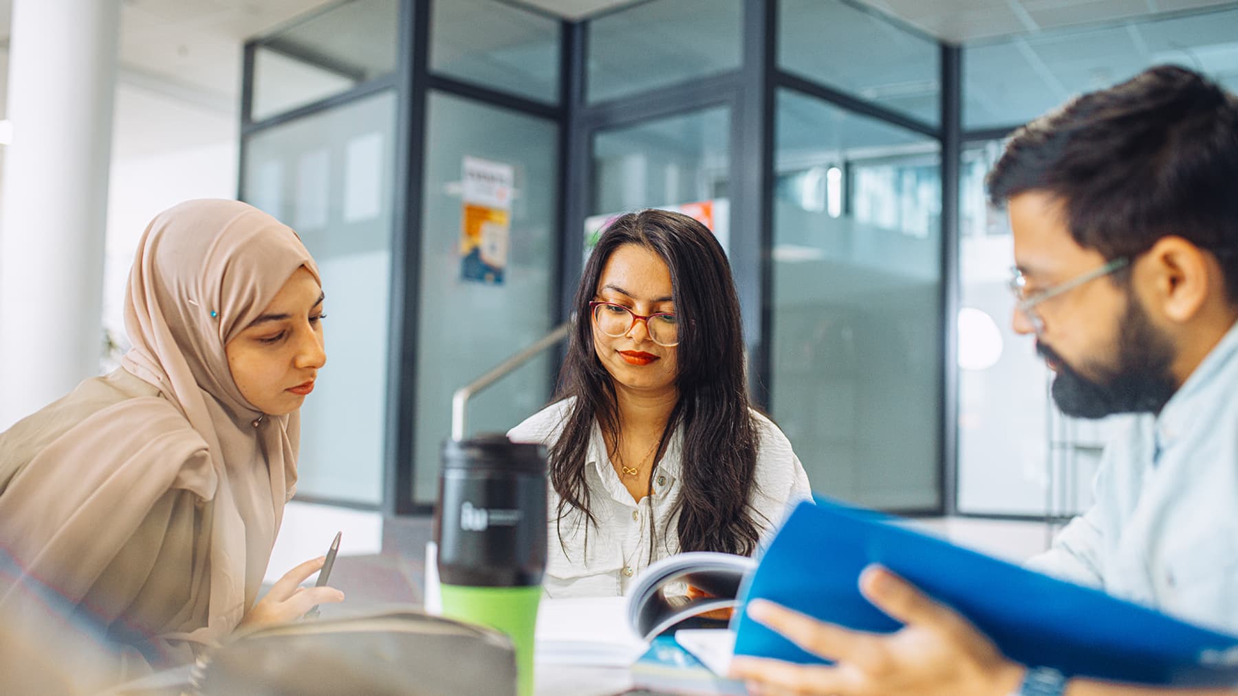 Three international students discuss their work togther