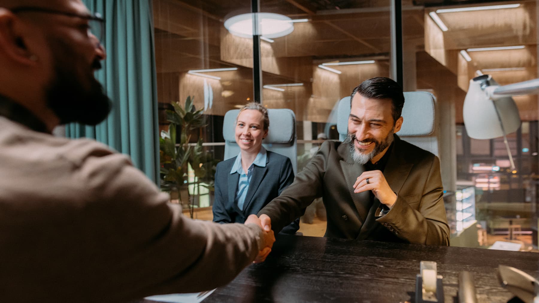 Shaking hands with software engineering professionals in a business meeting