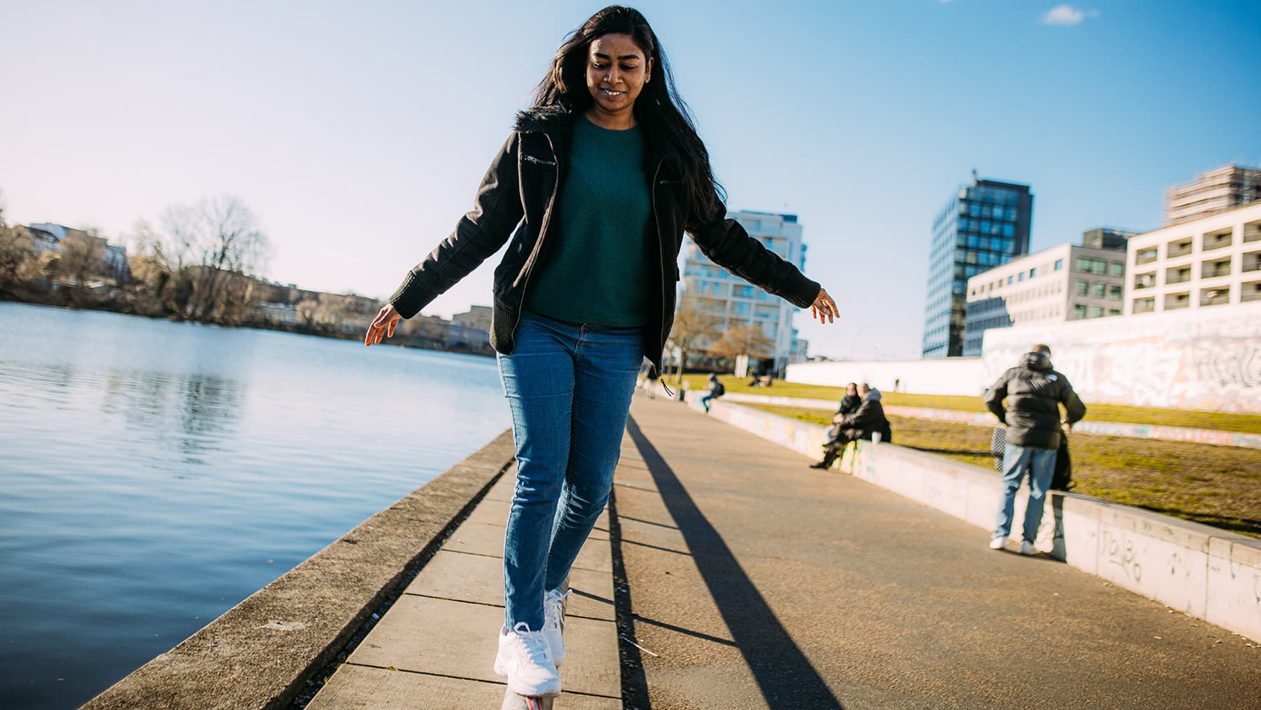 Cheerful woman walking next to the Spree River in Berlin.