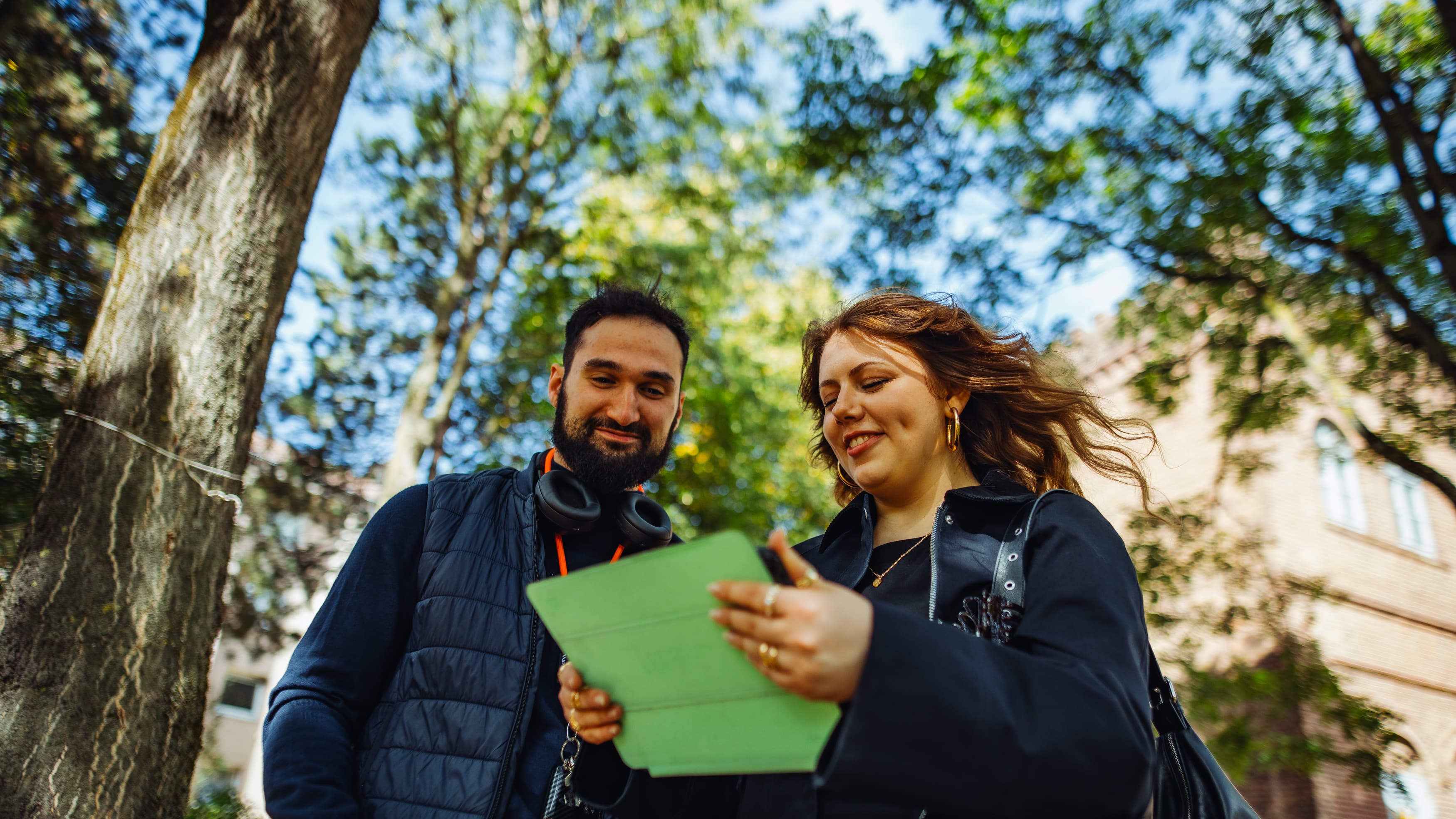 A pair of IU students checking some notes on an tablet while enjoying the nature