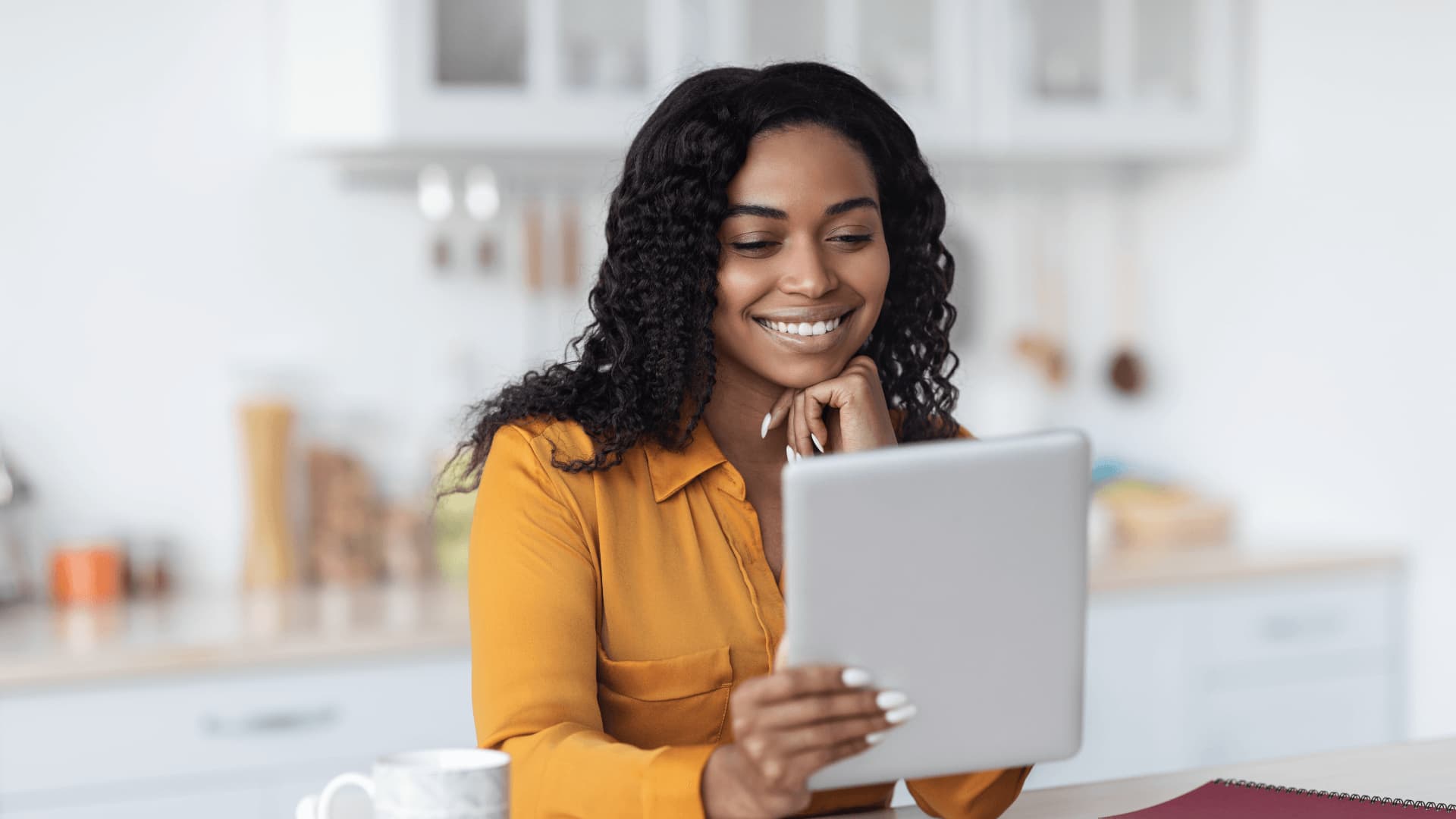 Smiling student saving living expenses for university by studying online from home.