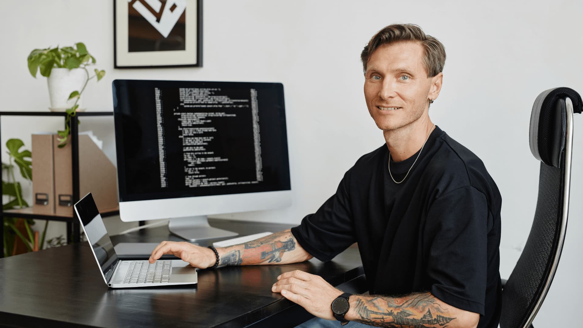 Man in black t shirt studying a technology data degree from anywhere in the world.