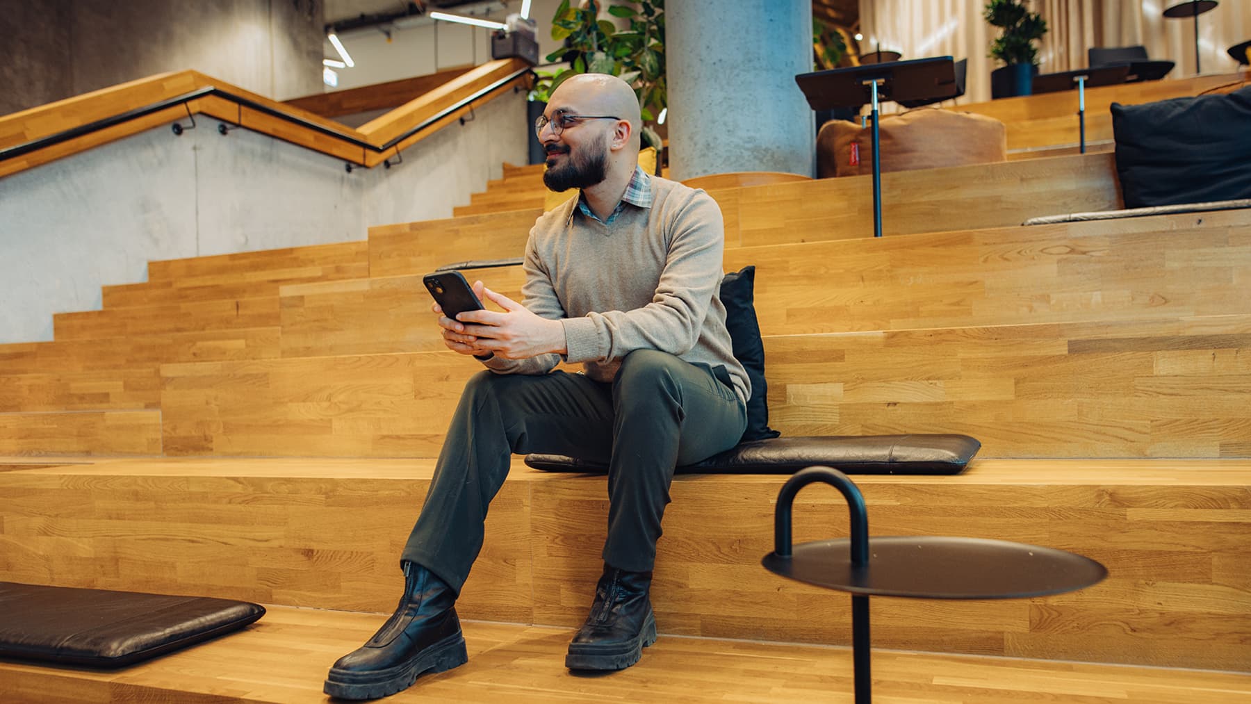 A student sits on a comfortable, wooden step in a modern lecture hall