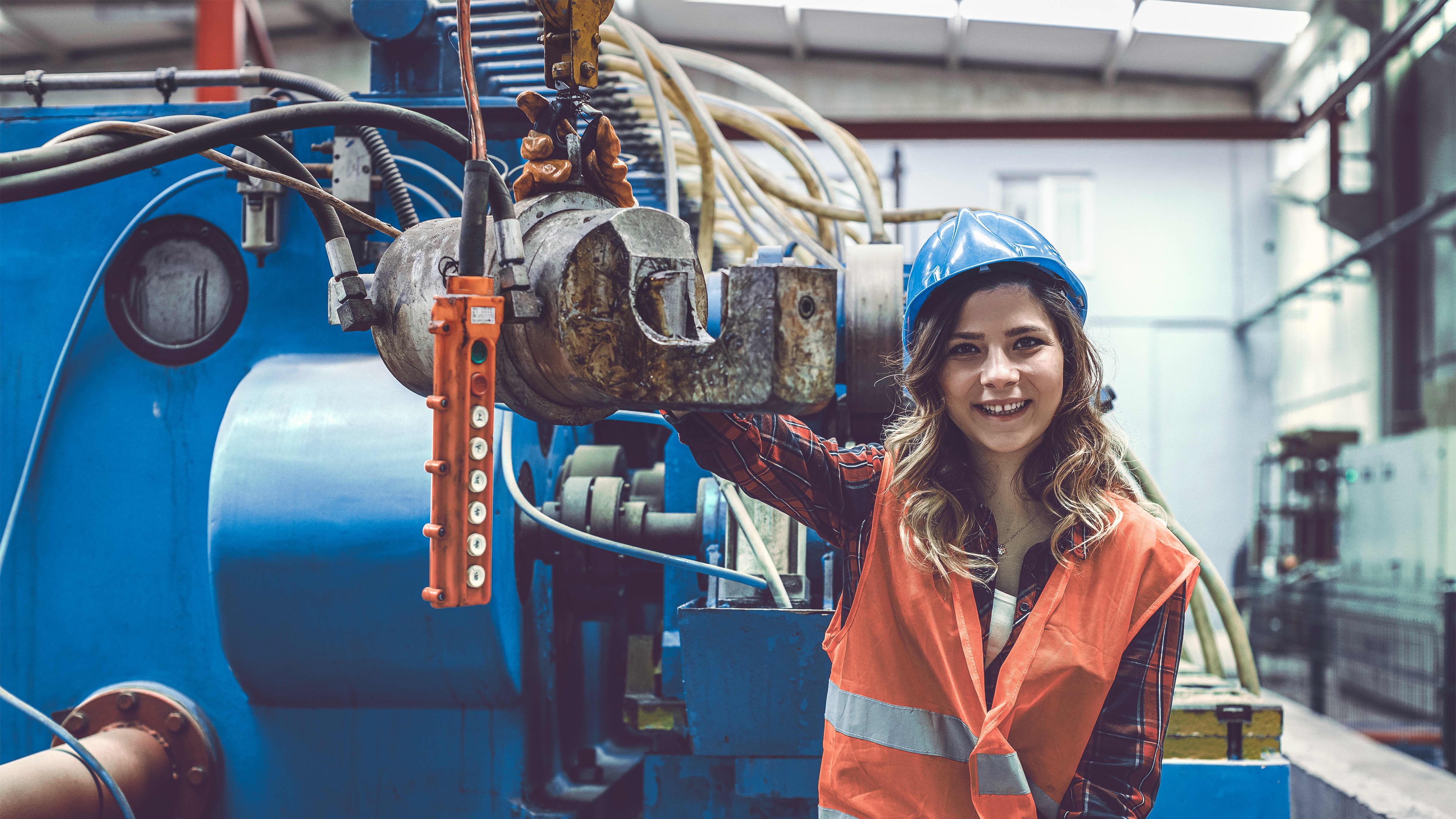 Titelbild auf Infoseite "duales Studium Mechatronik": Duale Studentin mit Schutzkleidung in Industriehalle