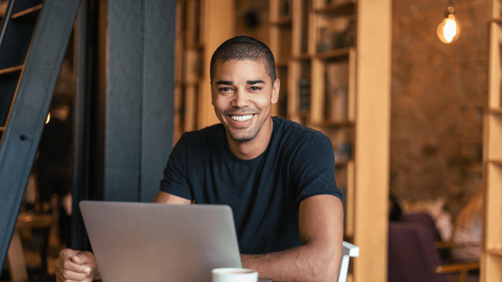 Smiling student starting their studies in a cafe