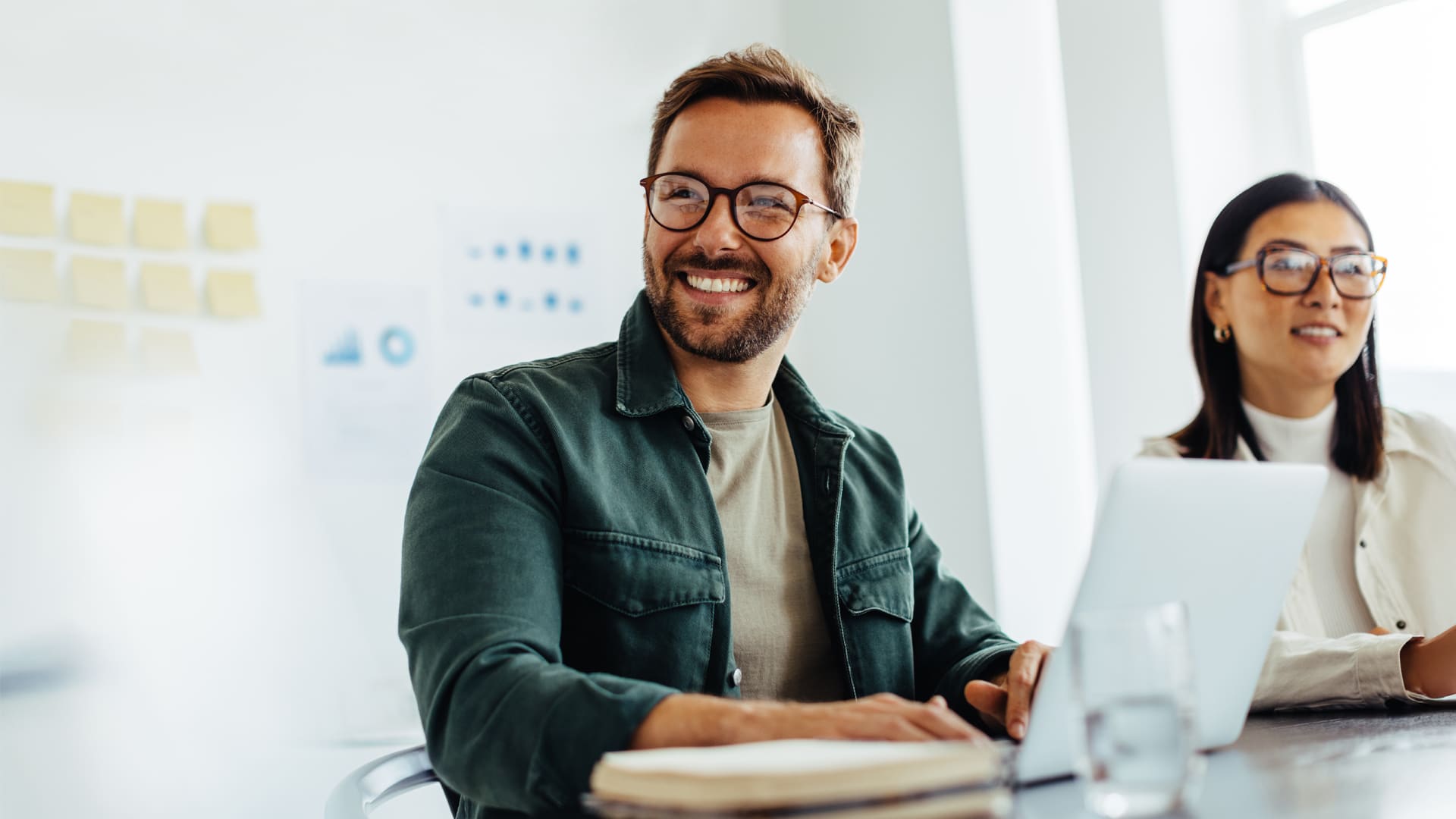 Smiling IT consultant sitting at desk in office.