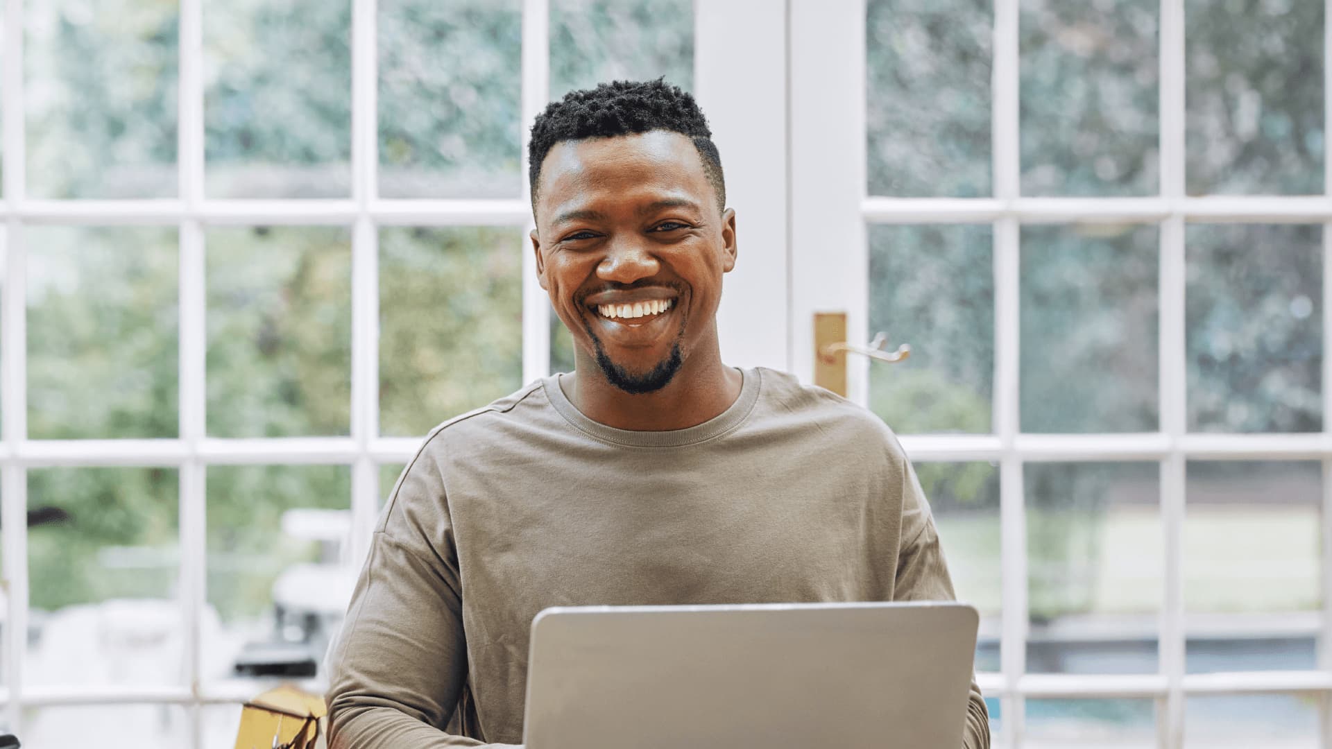 Smiling man studying an online programme with other part-time students while working full-time.