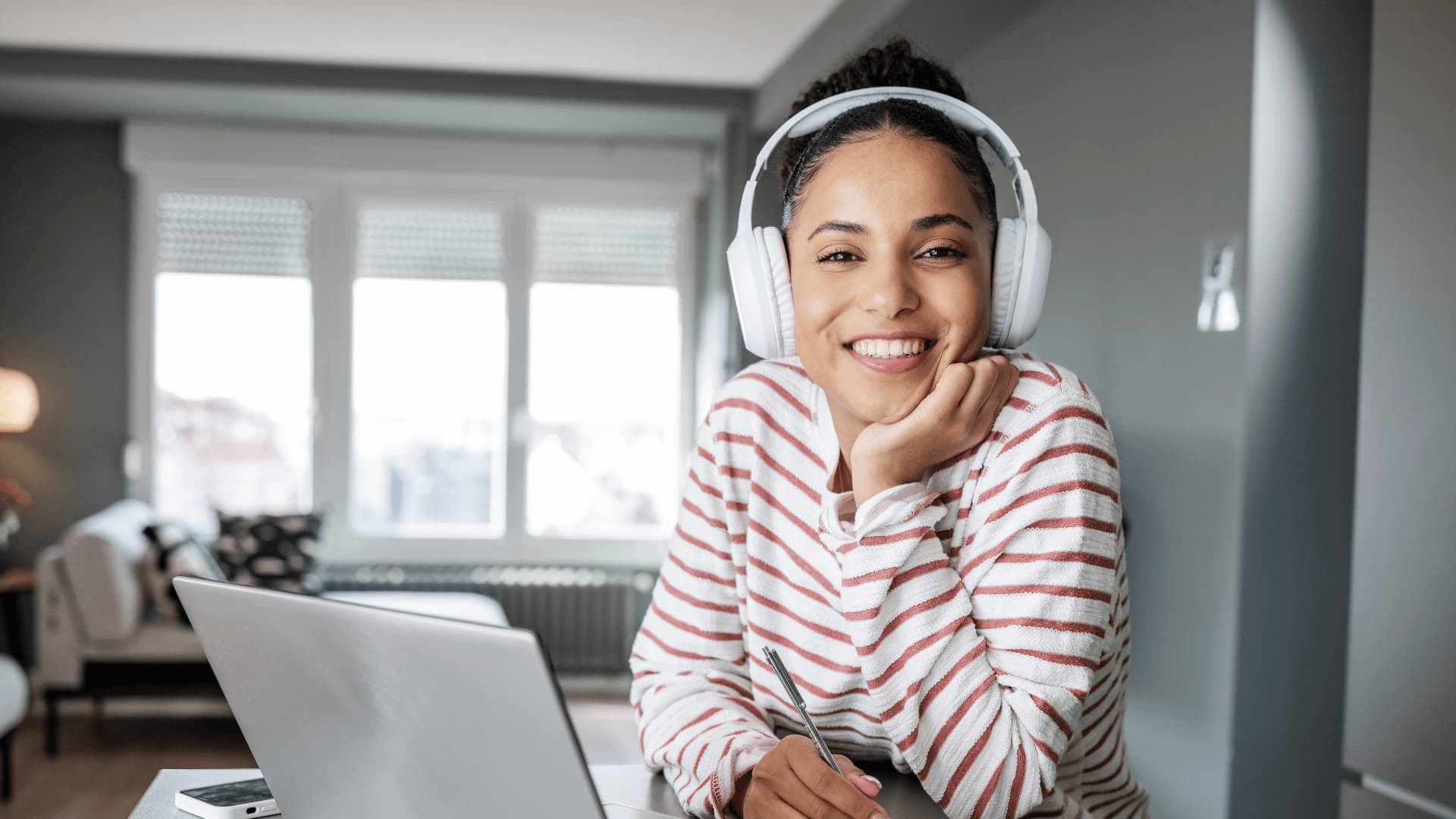 Woman in headphones and striped white shirt in a personal video consultation with LIBF Study Advisors.