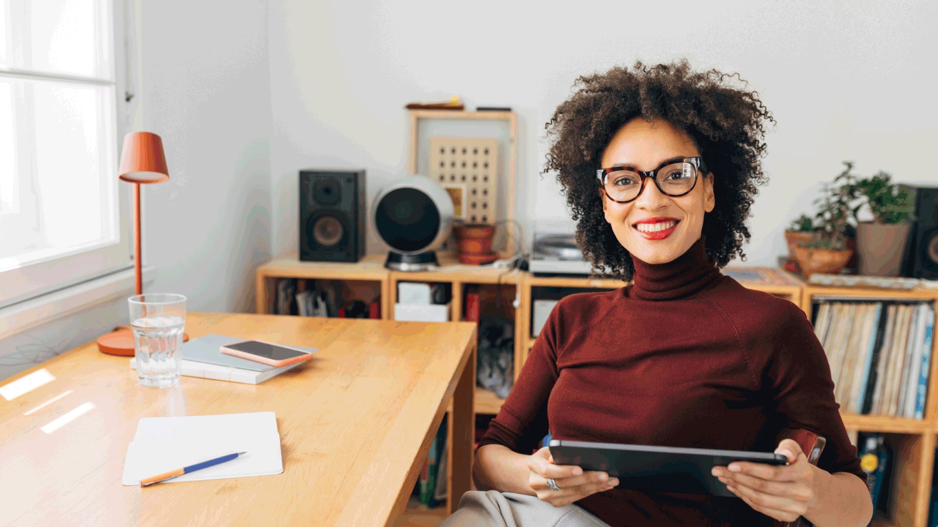 Student sitting at a desk with a tablet and notes, researching when to apply for degree that starts in January.