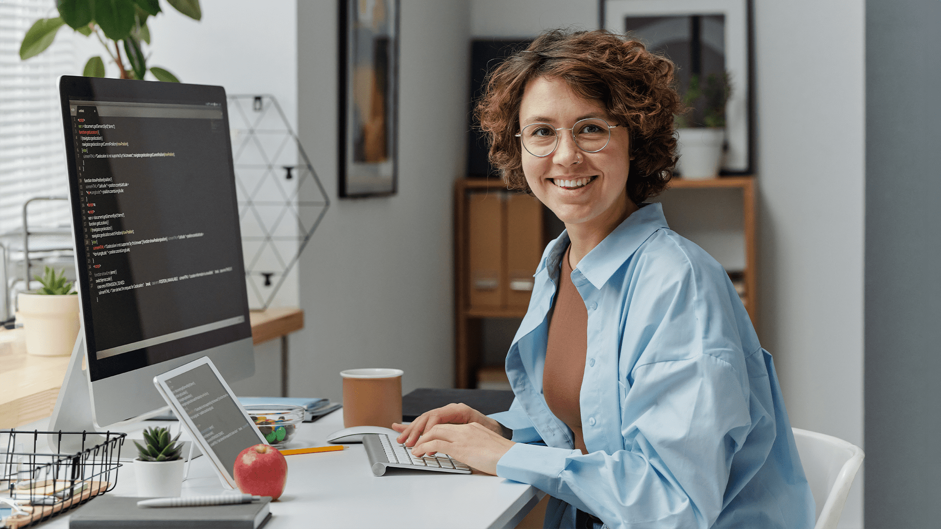 Happy woman sitting in her modern office working on implementing effective business intelligence systems