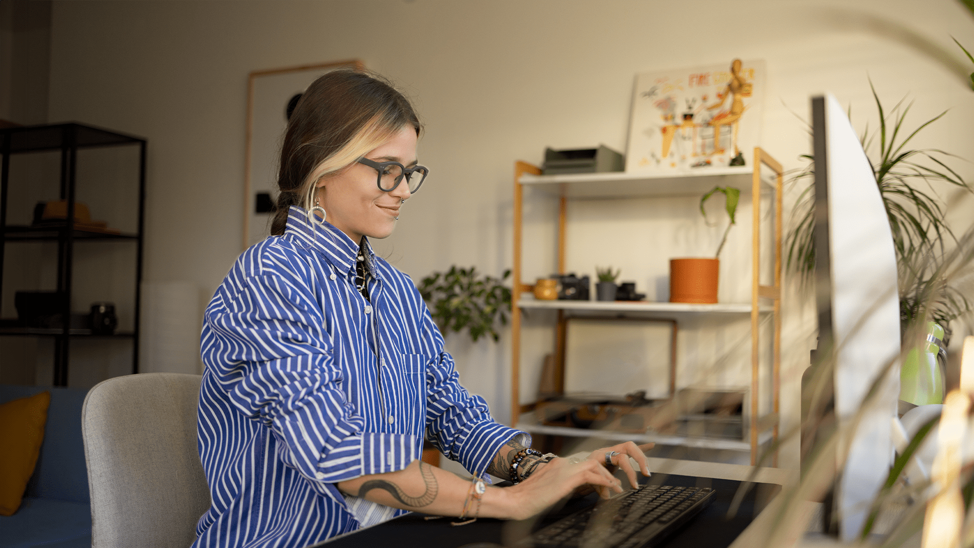 Cool woman with tattoos wearing a striped shirt working as a business systems analyst