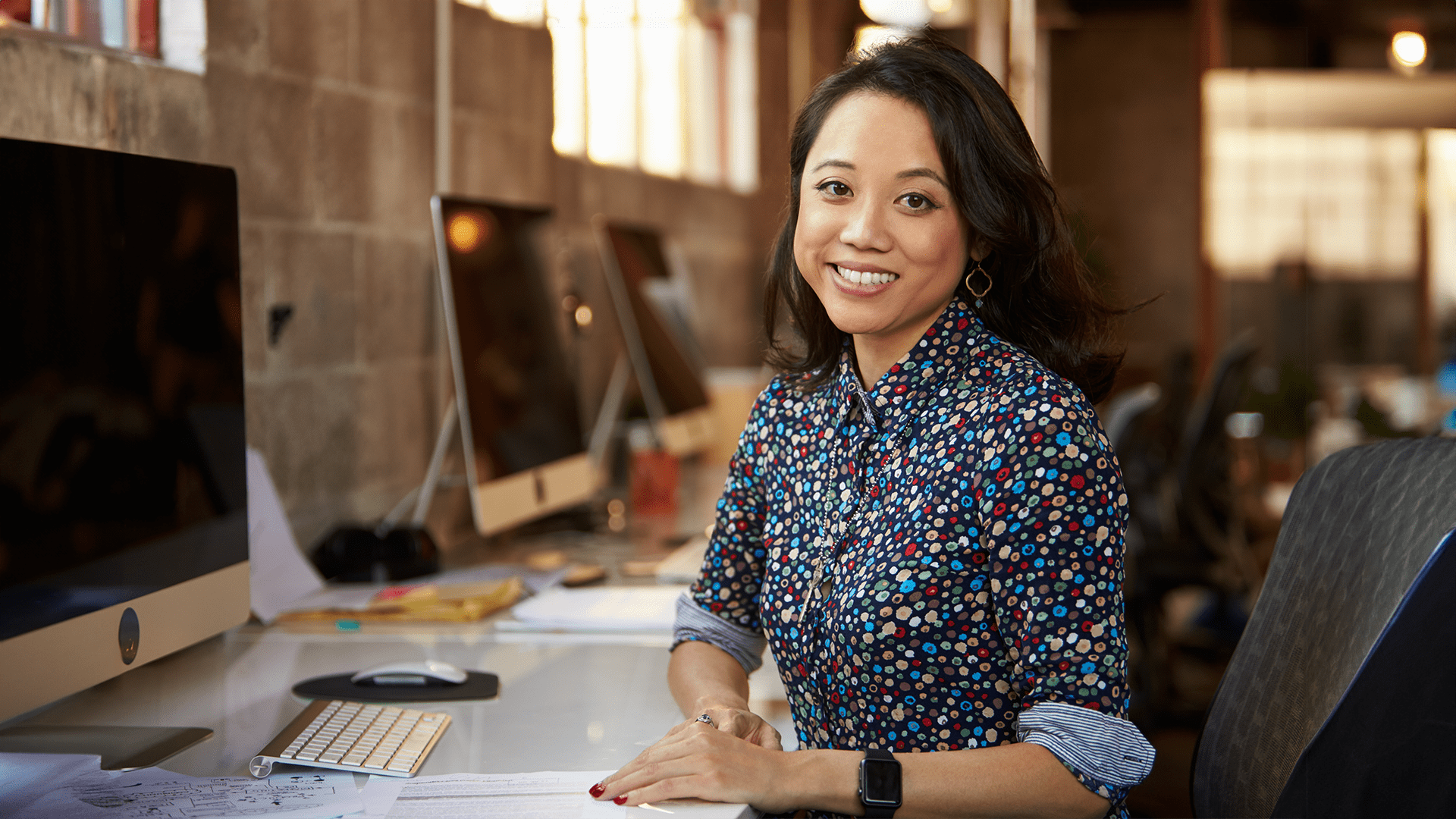 Woman wearing a floral shirt working alone at her office on developing policies for physical and digital data protection