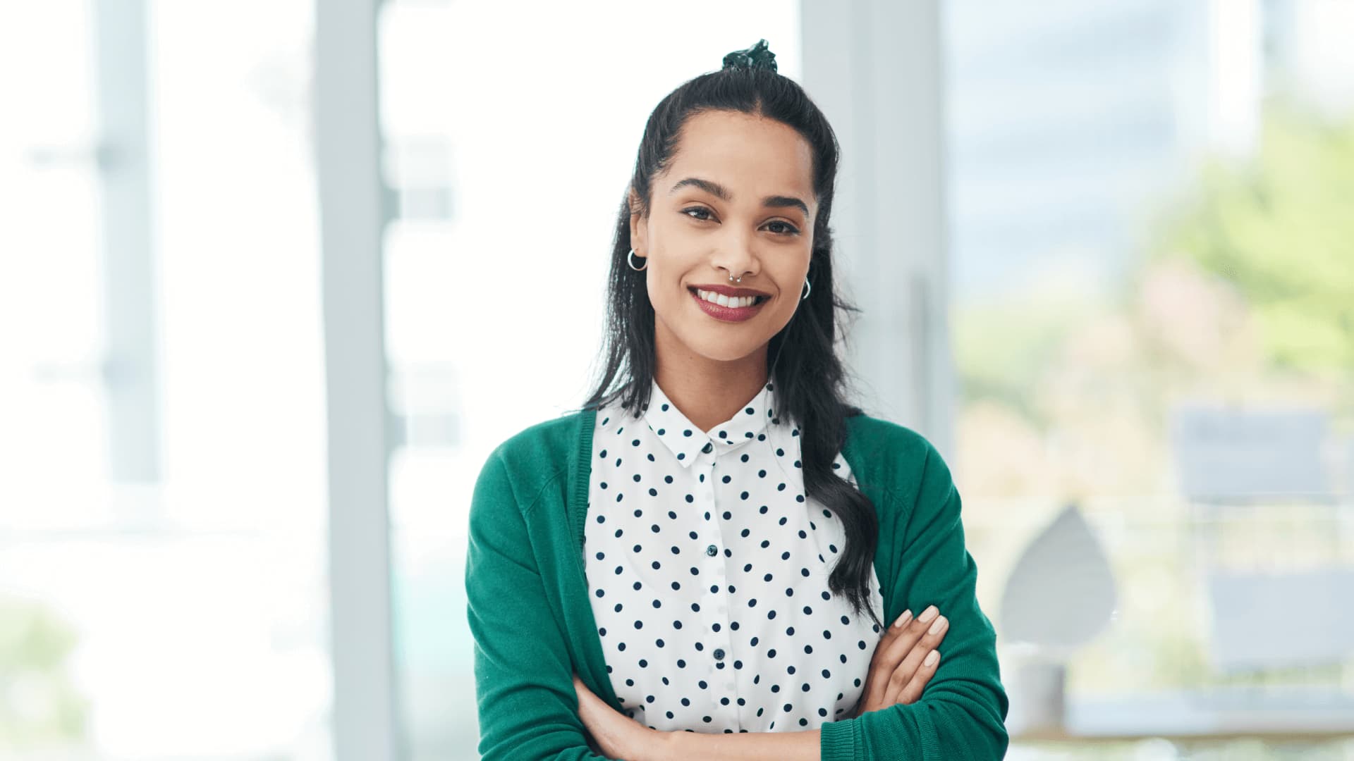 Woman in green cardigan working in employee relations after online learning courses.