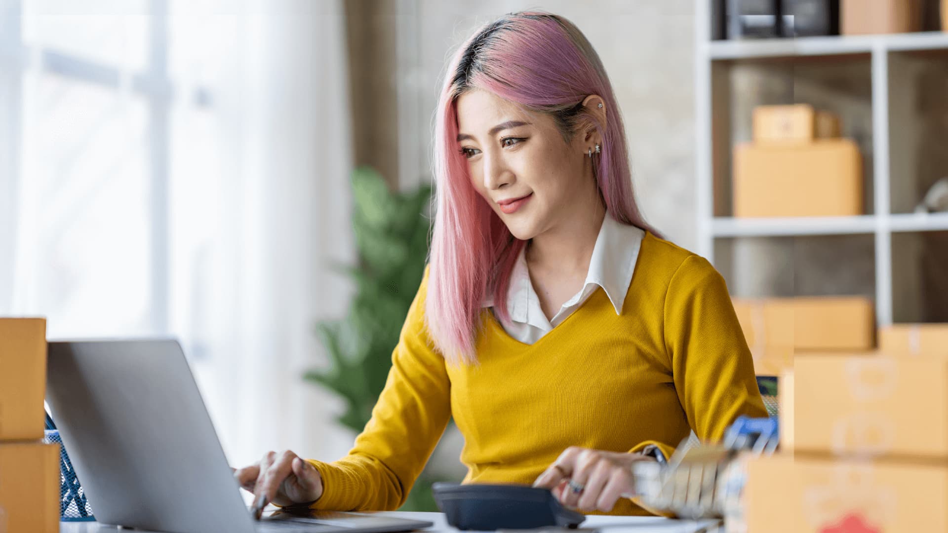 Woman with pink hair wearing a yellow blouse is working as a solution architect