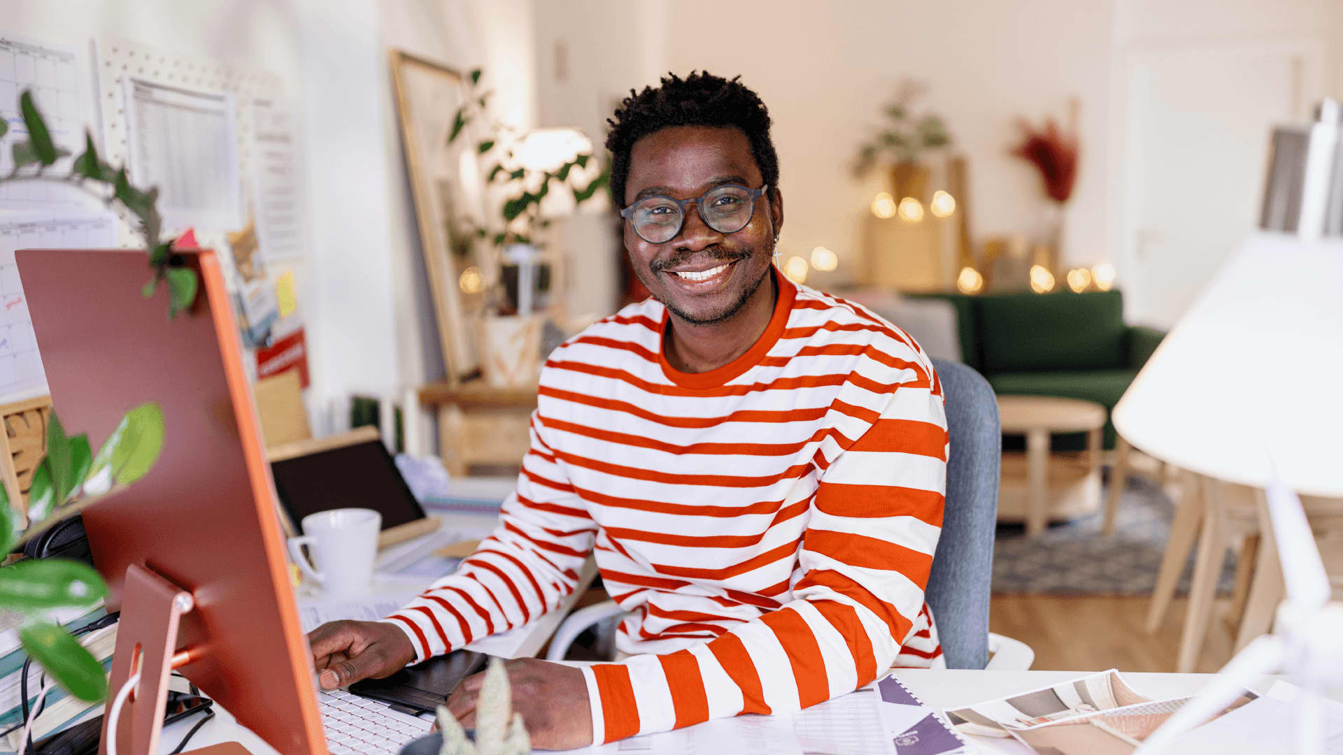 Smiling man in striped jumper studying people management in a global context at his own pace.