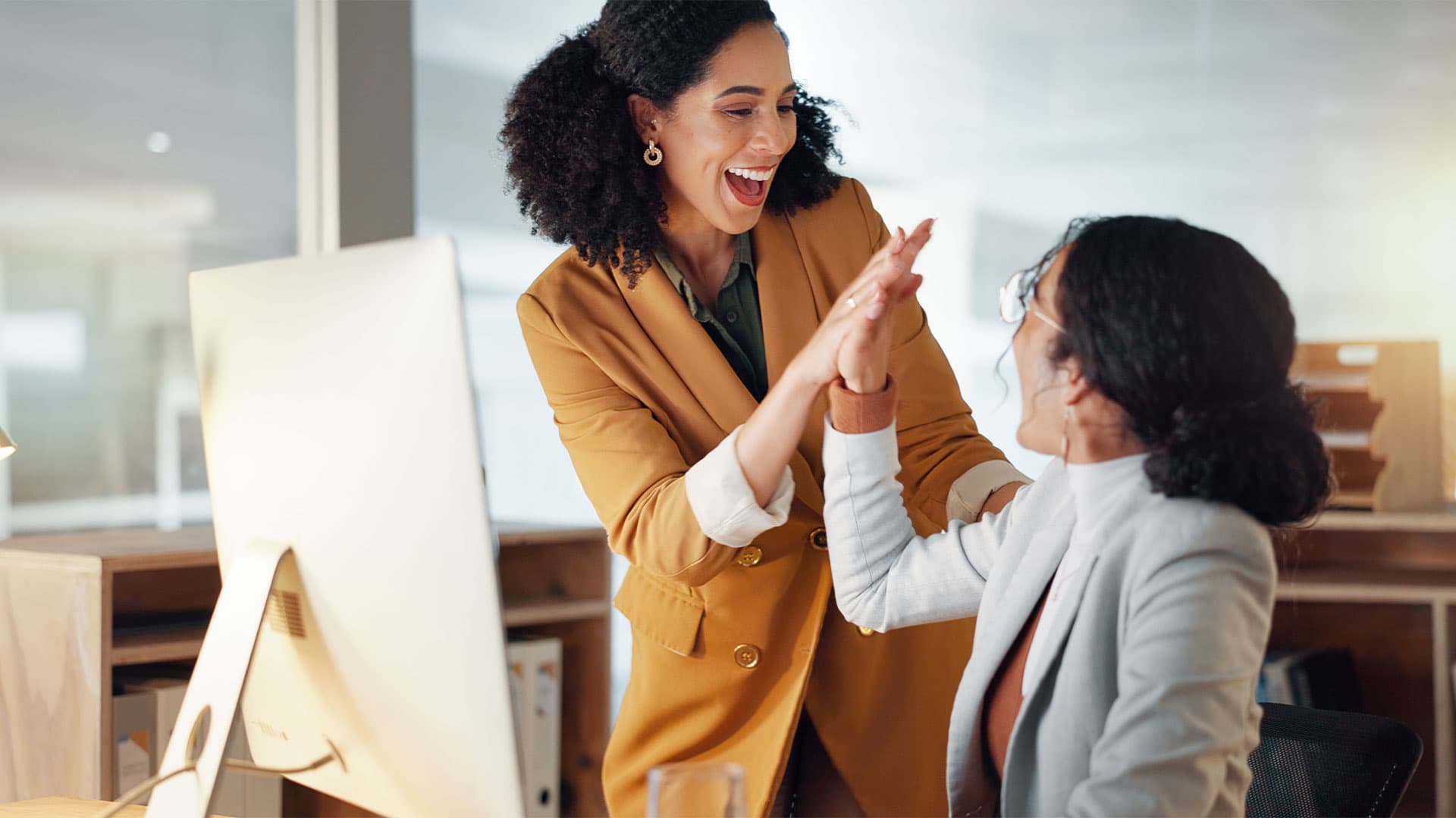 A woman giving a high-five to another woman.