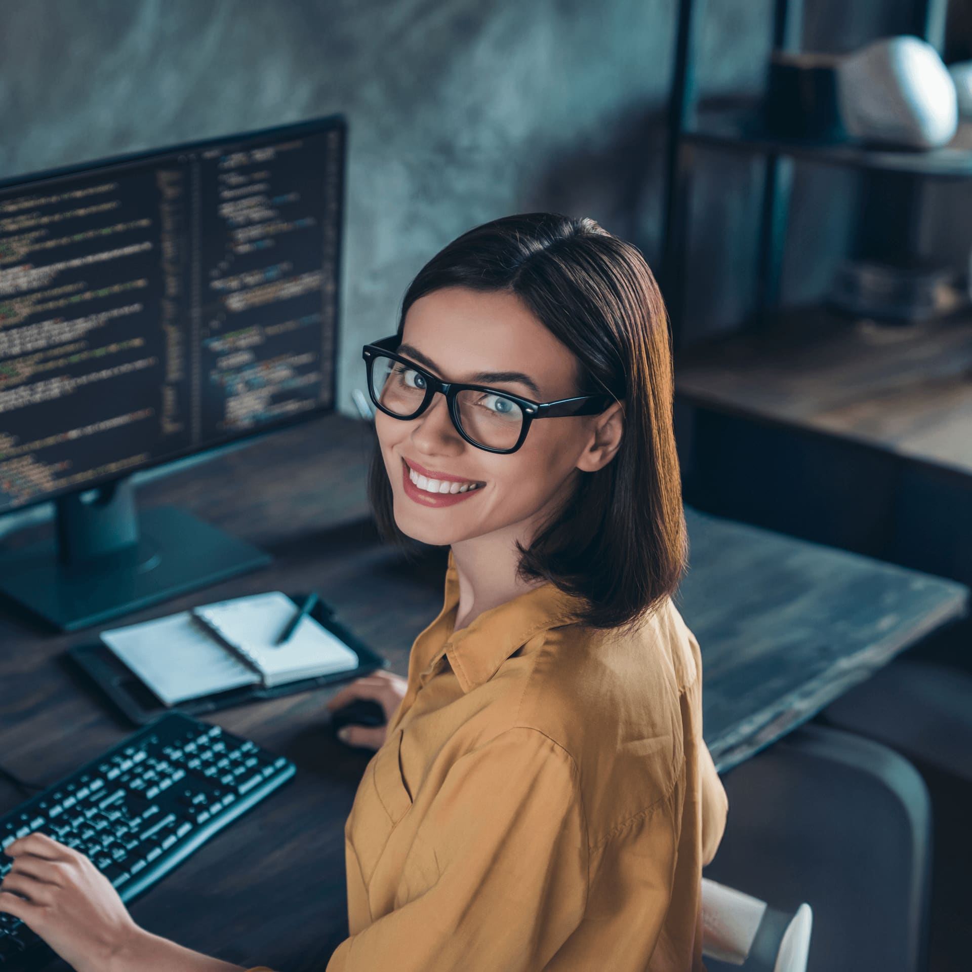 Happy female cybersecurity expert in orange shirt working from home.