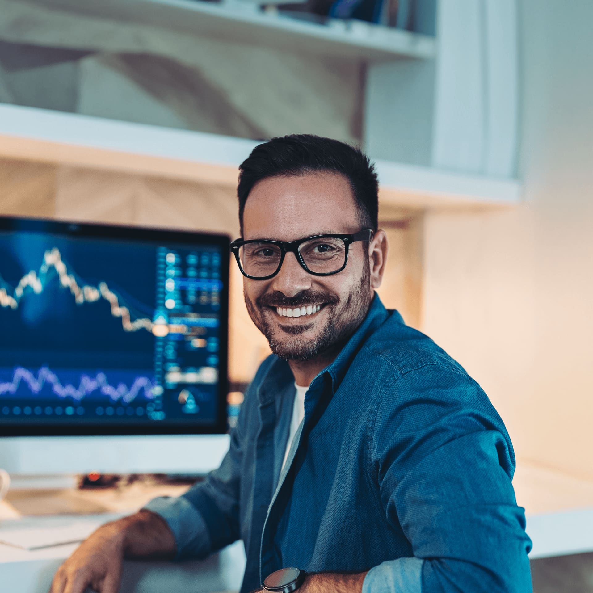 Smiling man in glass in front of a computer data software programme.