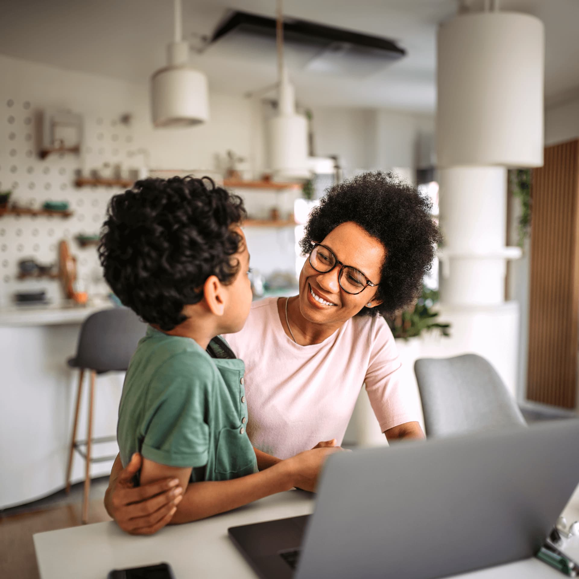 Mother sat with child at laptop looking for a part-time study programme online.