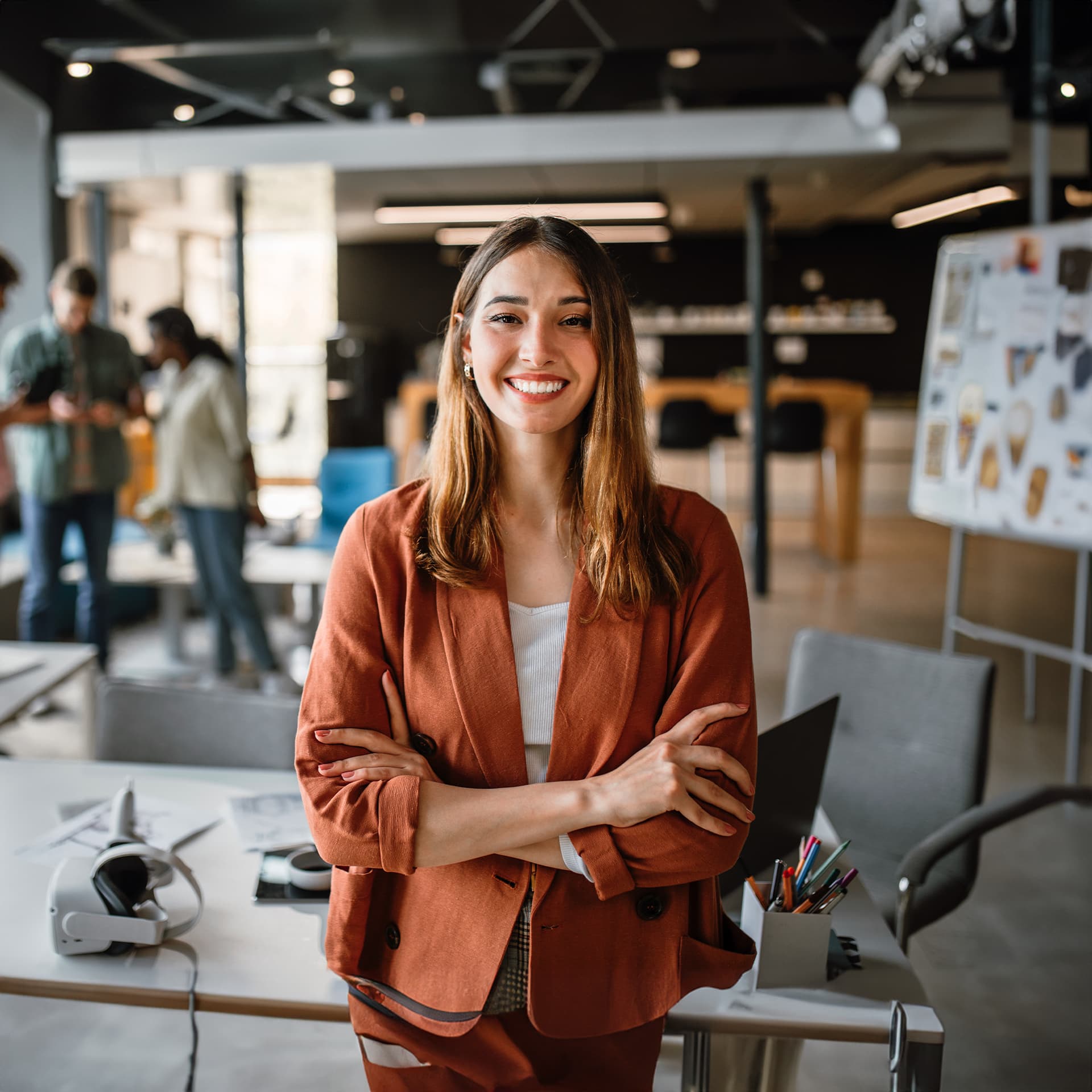 Elegant woman wearing an orange blazer looks happy that she completed her software development degree