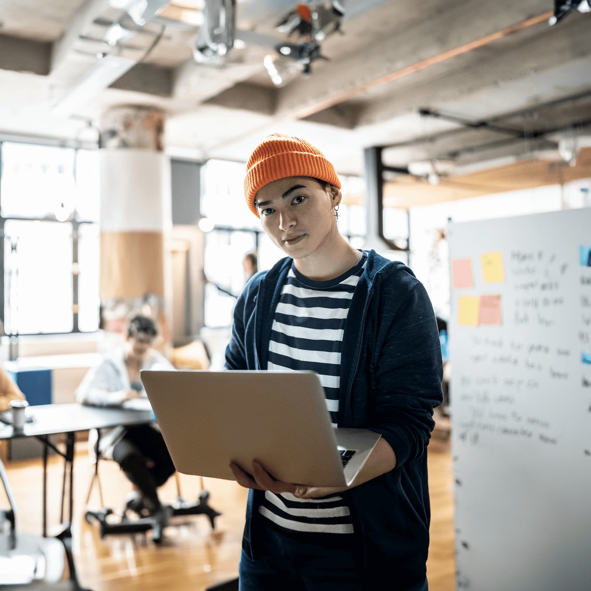 Guy wearing an orange beanie attending his online classes on artificial intelligence