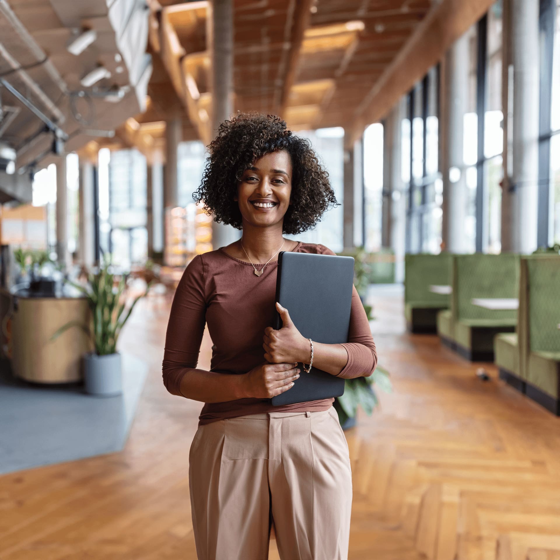 Curly hair woman holding her laptop looks happy with her choice to study online master in data science