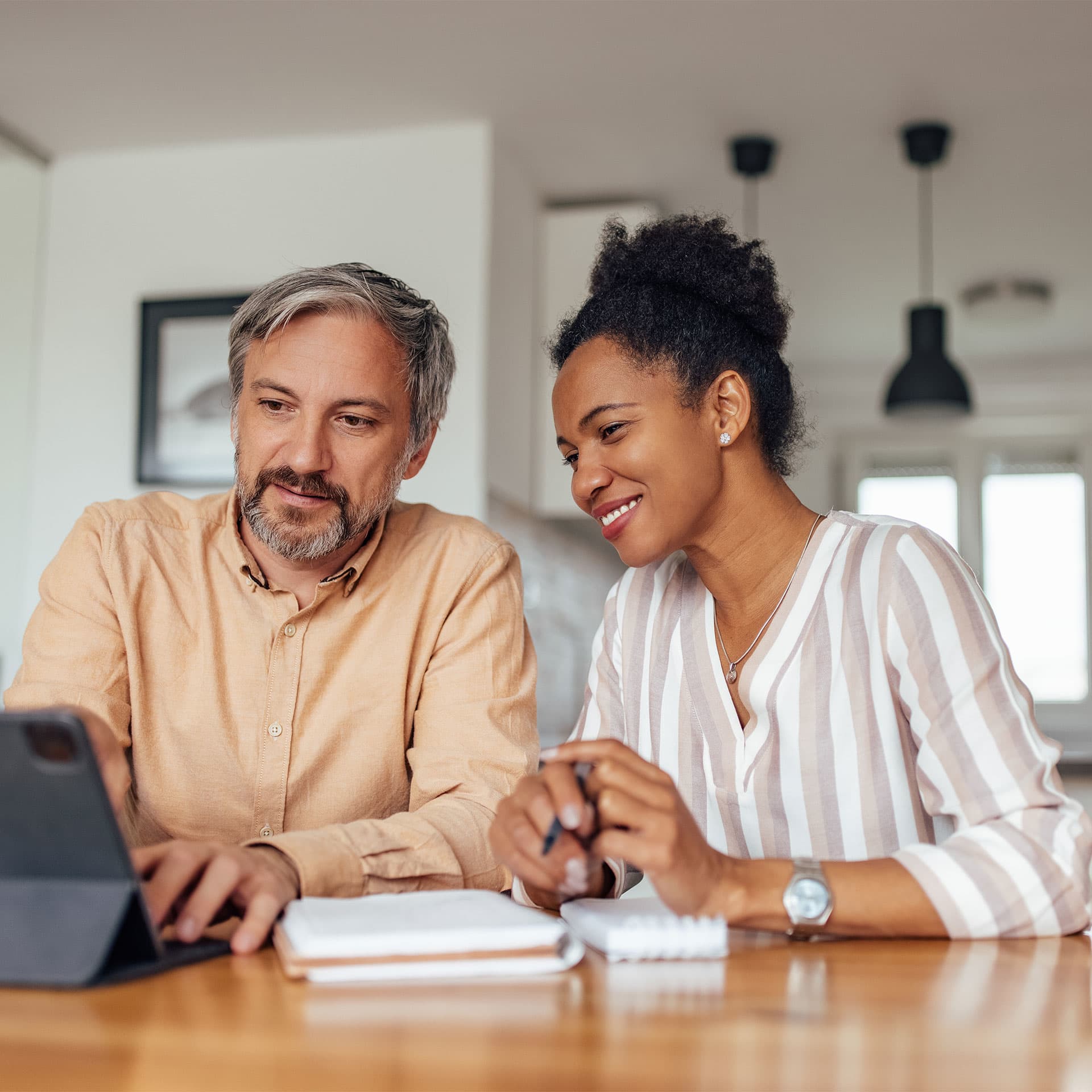 A man and a woman looking at an ipad.