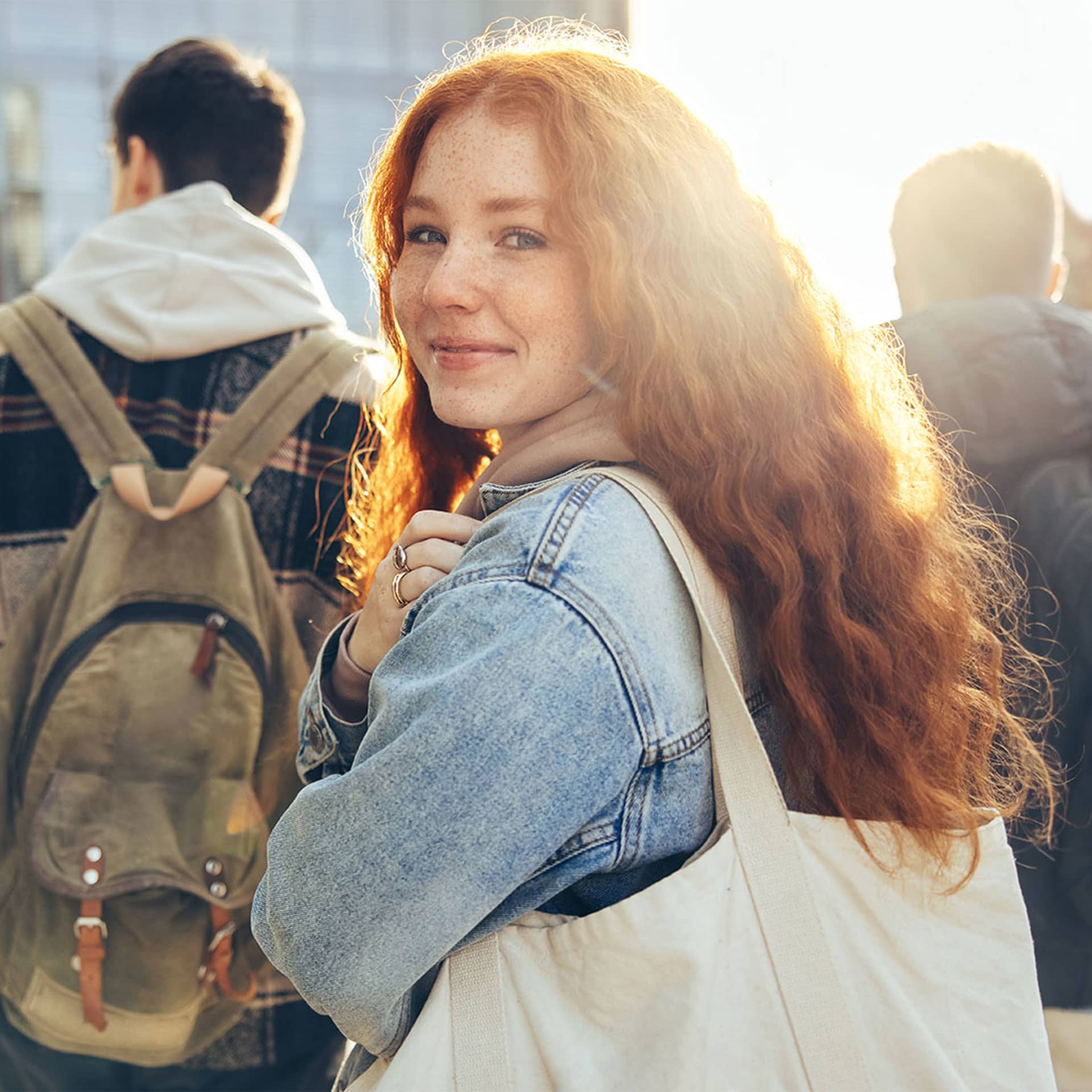 A young girl with curly hair is looking over her shoulder.