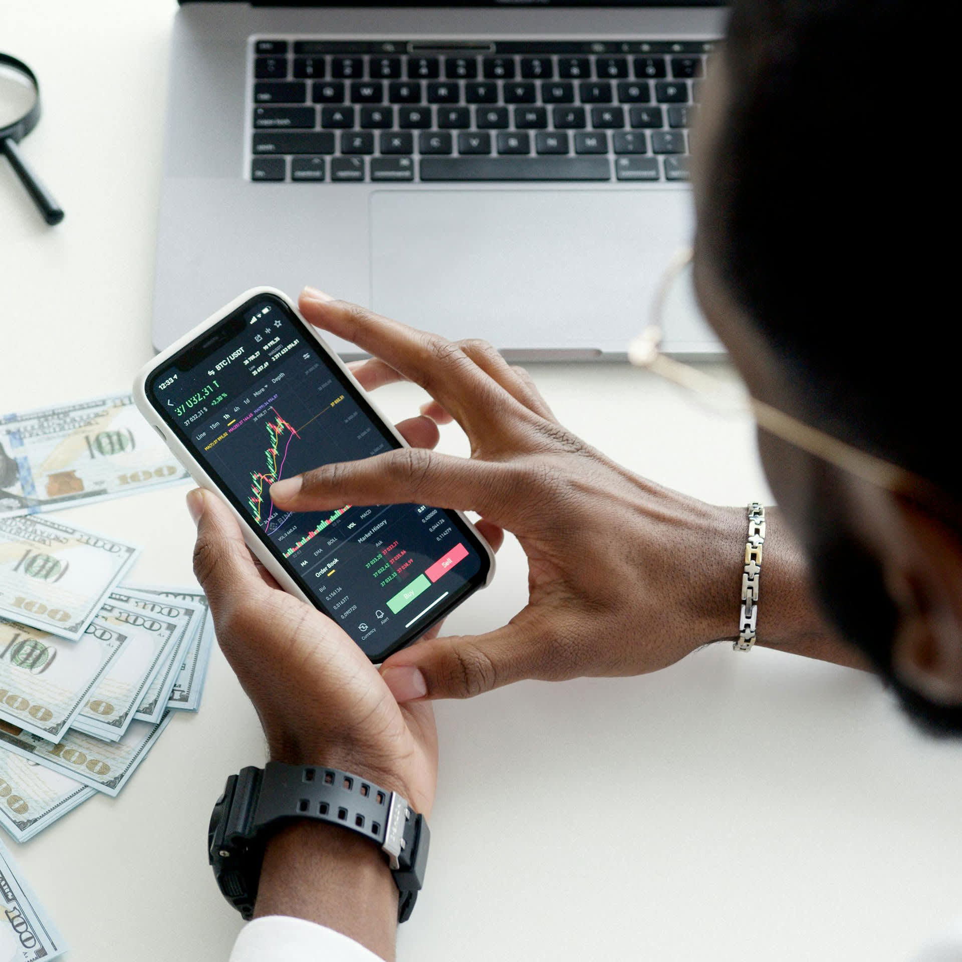 A person holding a phone that is showing the stock market.