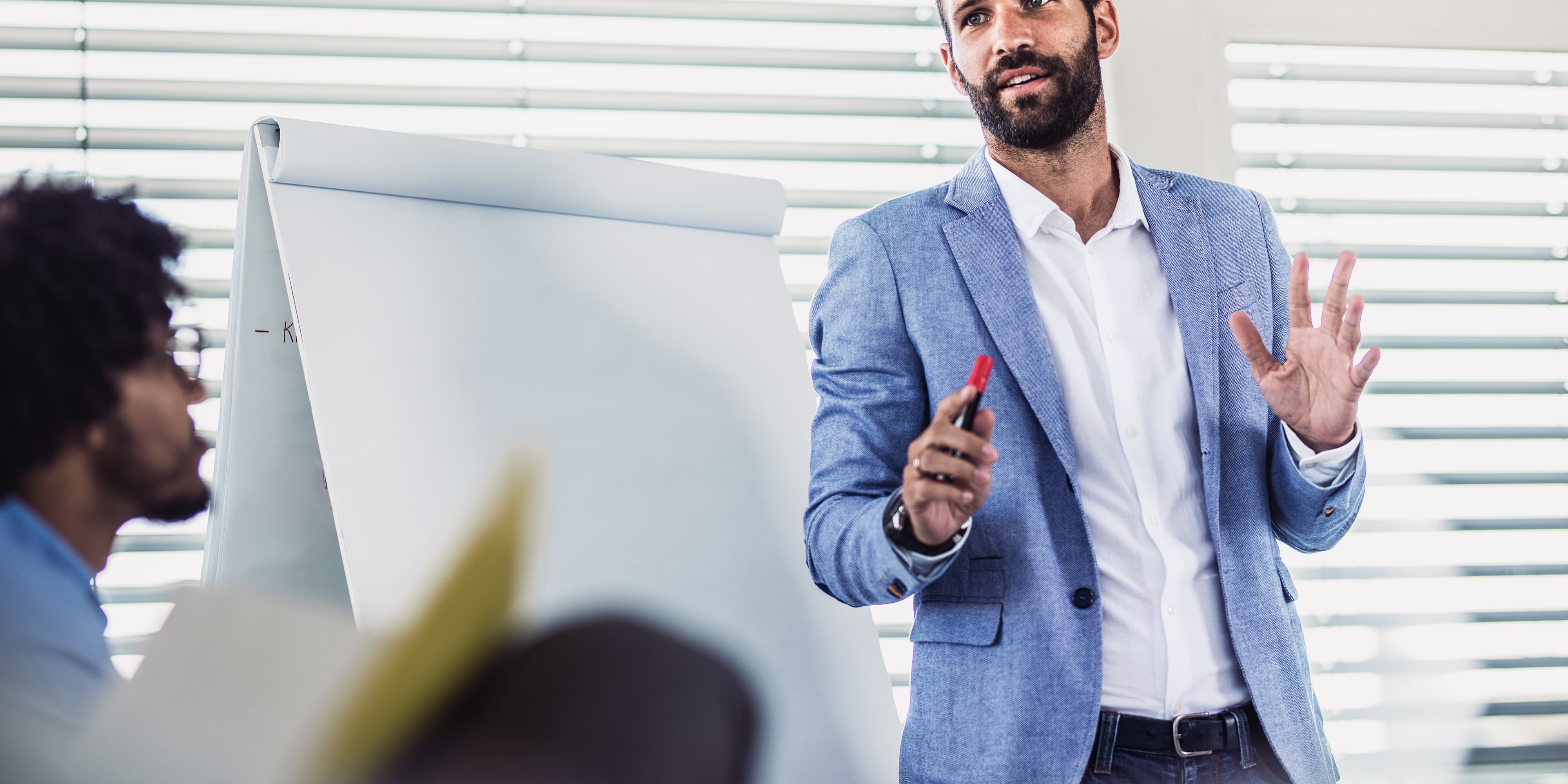 Titelbild für Infoseite “Master International Healthcare Management”: Produktmanager steht vor Whiteboard in Konferenzraum