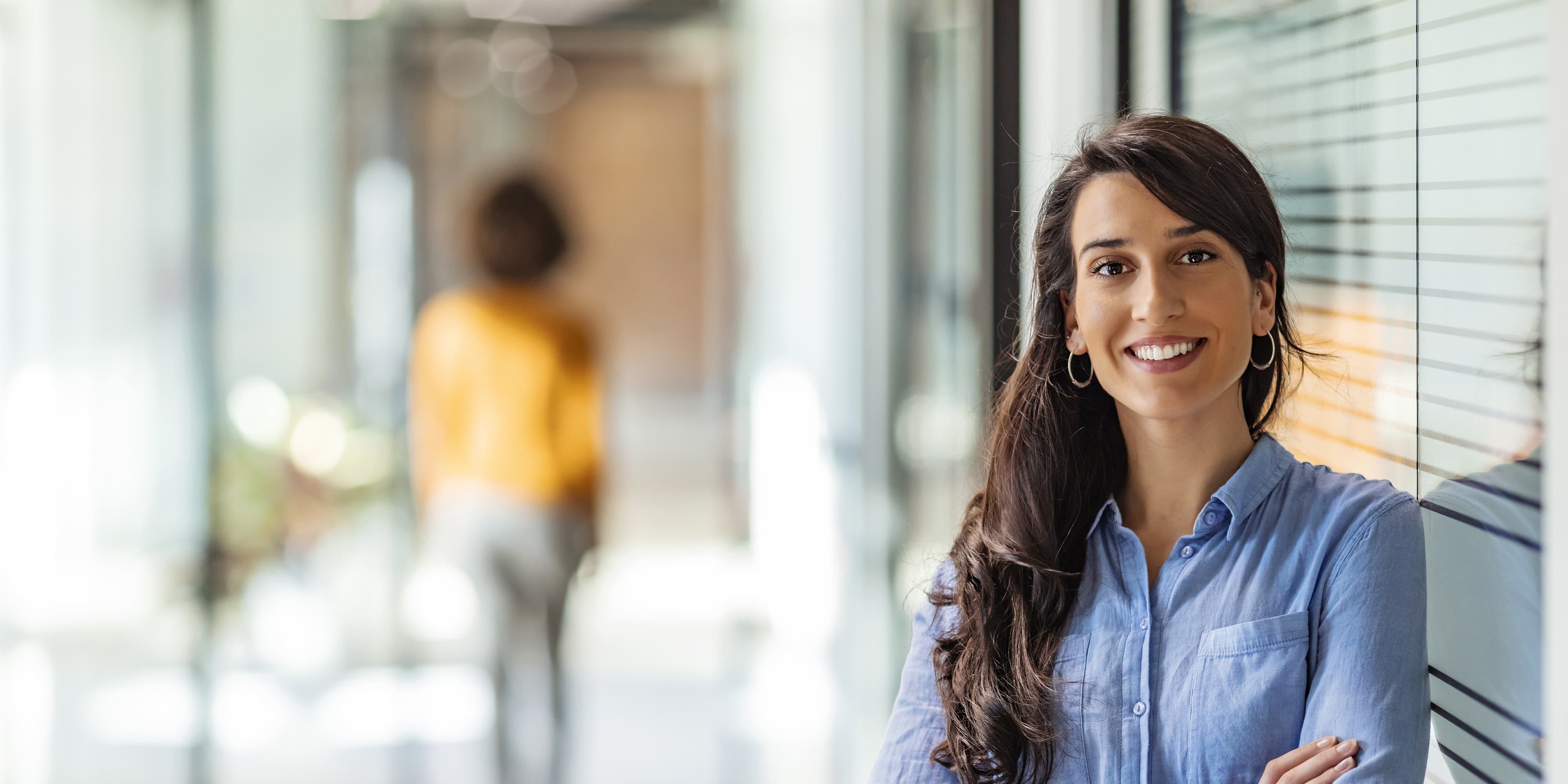 Titelbild für Infoseite “Bachelor Wirtschaftspsychologie”: Lächelnde selbstbewusste Frau im Büro