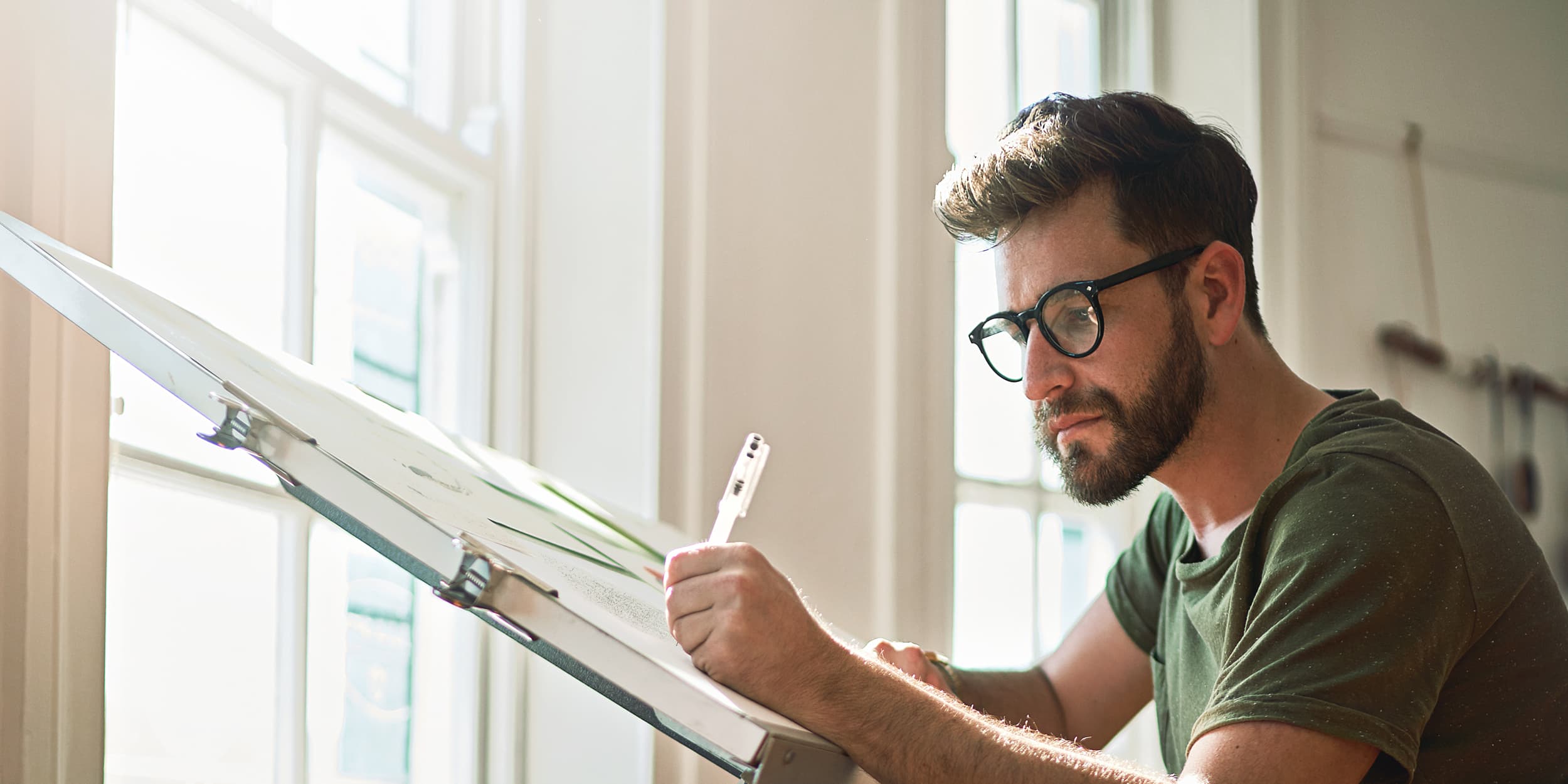 Titelbild für Infoseite: "duales Studium Architektur und Bau": Architekt beim Arbeiten an Schreibtisch