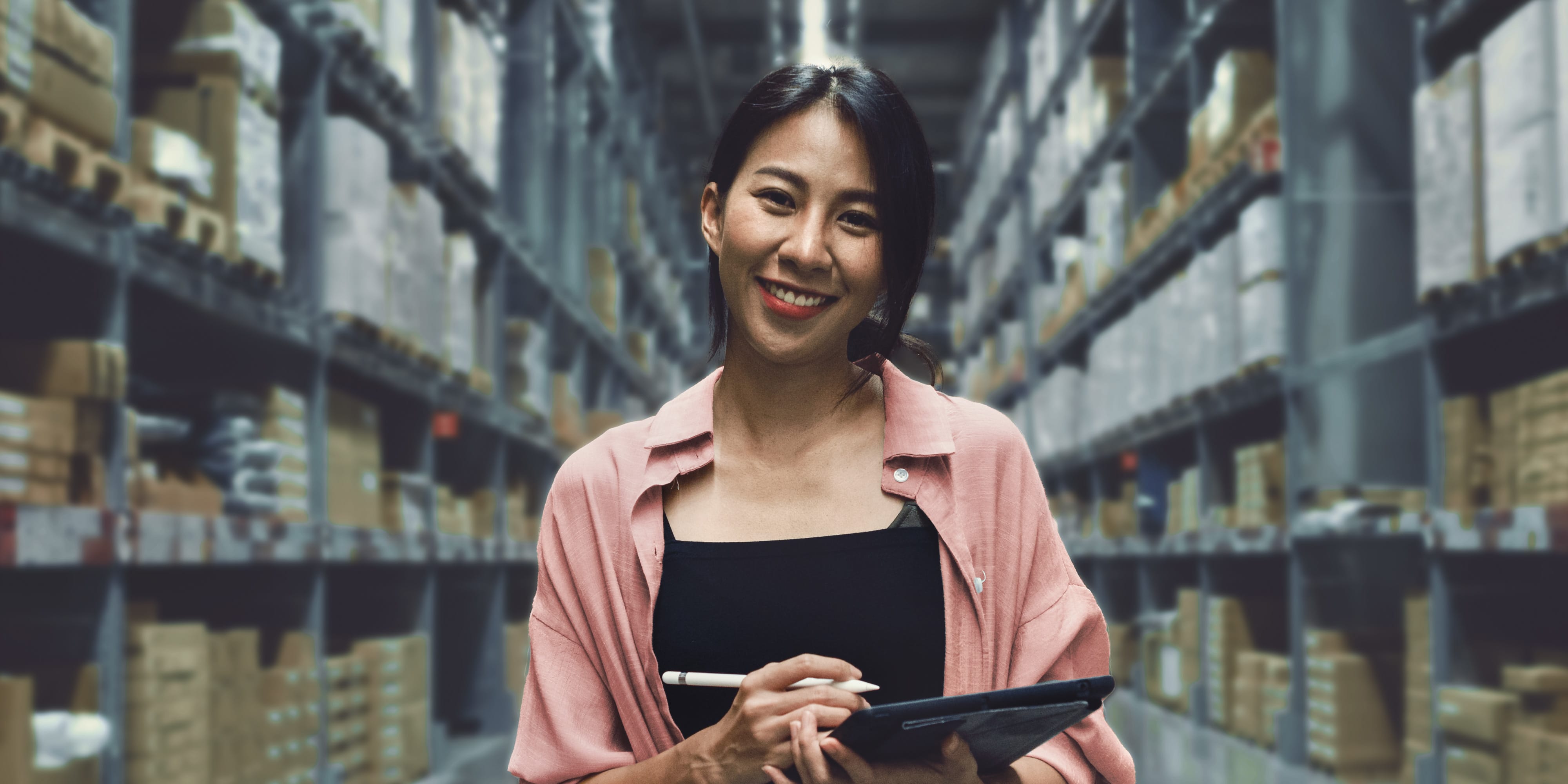 Titelbild für Infoseite “Bachelor BWL Logistikmanagement”: Studentin mit Tablet in einem Logistikzentrum