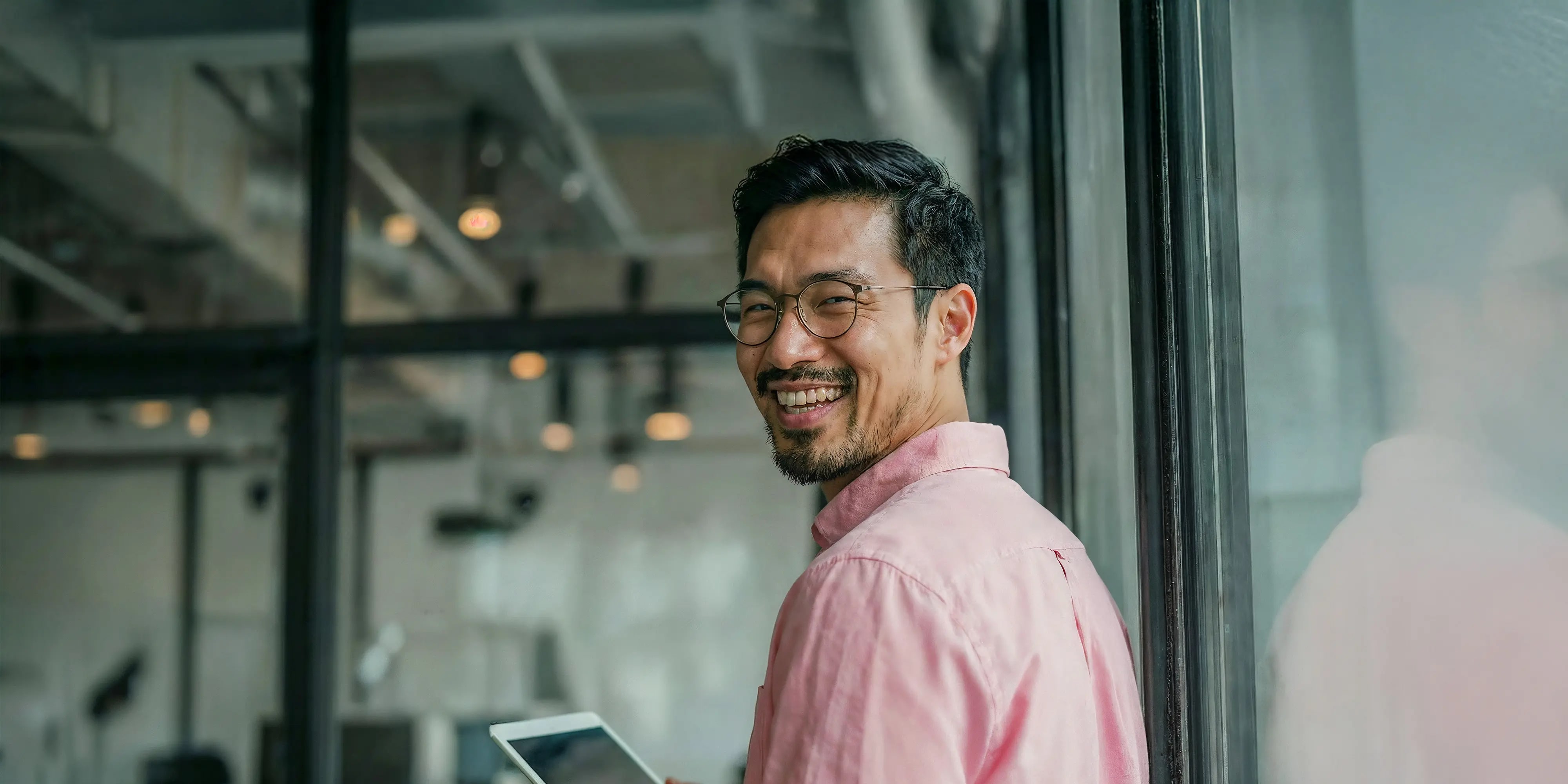 Bachelor Wirtschaftsrecht: Mann mit Tablet in der Hand steht vor Büro
