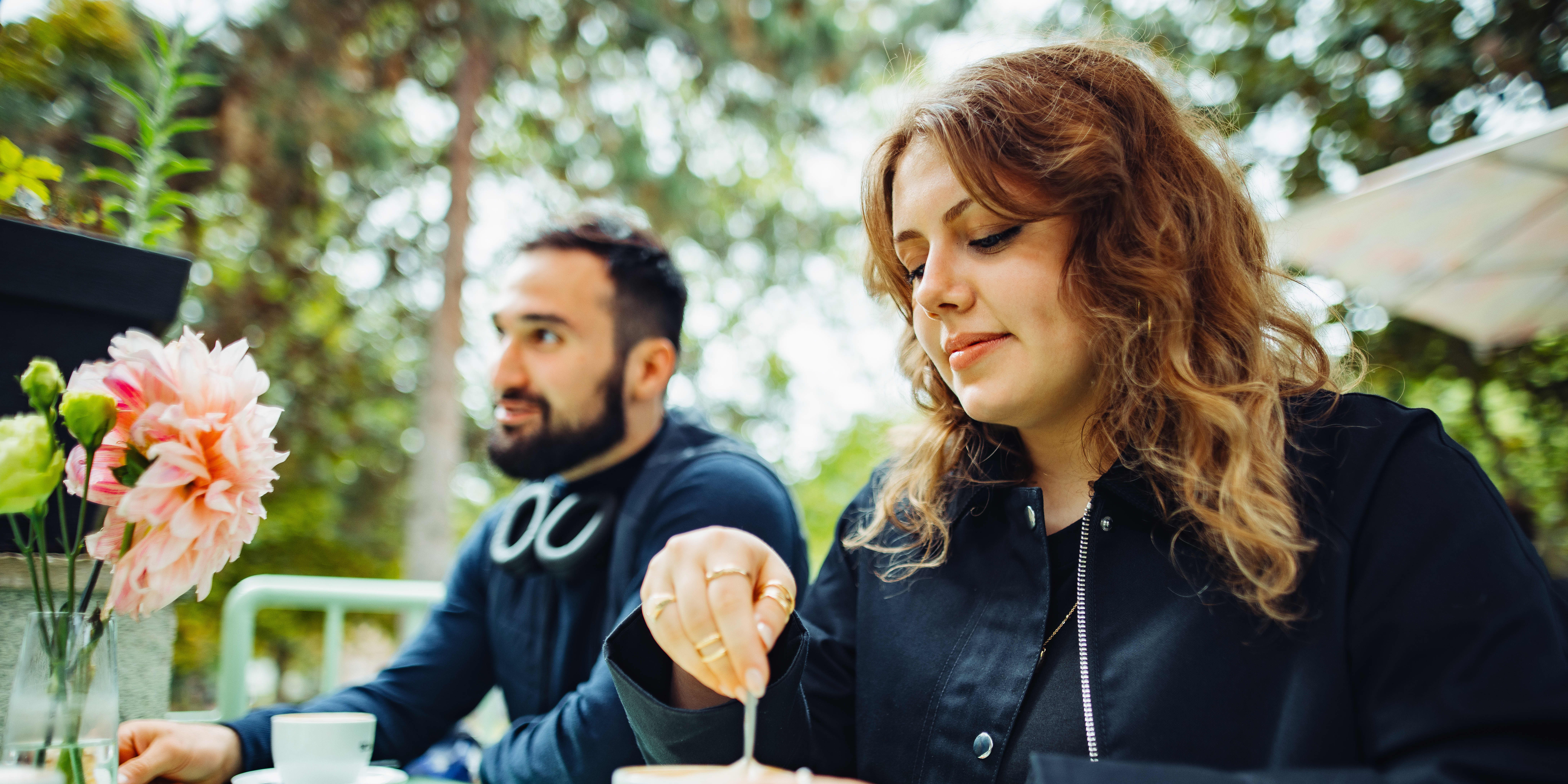 Man and woman enjoying coffee together at an outdoor café.
