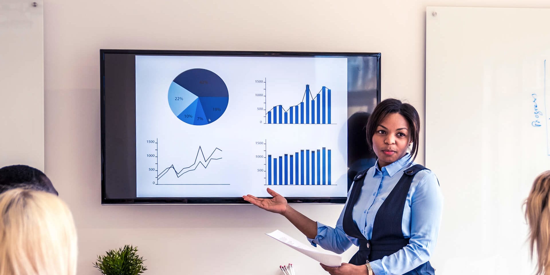 Confident MBA Banking and Finance graduate presents growth charts in a professional boardroom discussion.