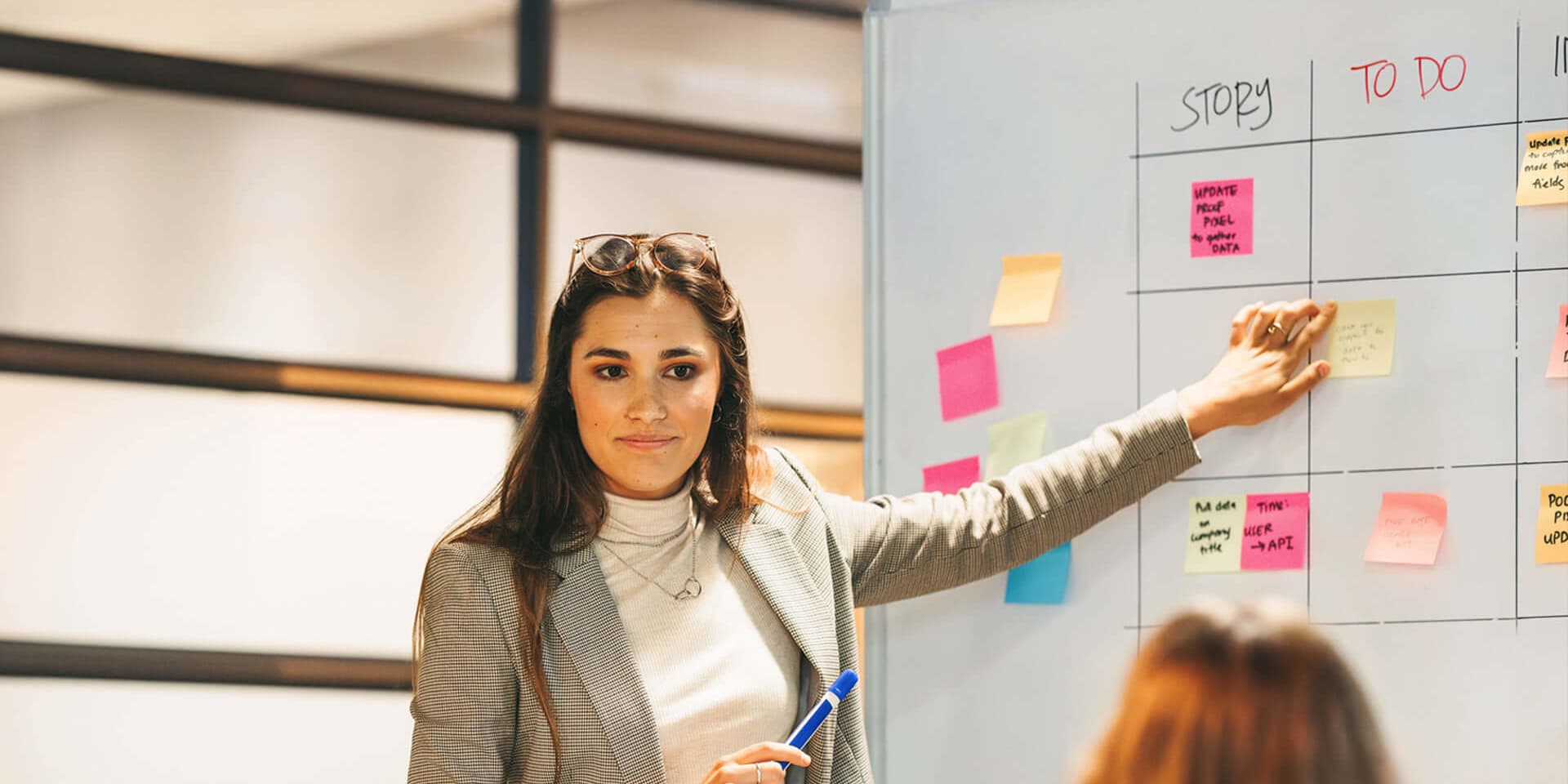 MBA Project Management graduate leads a task planning session, updating her team using an agile board.