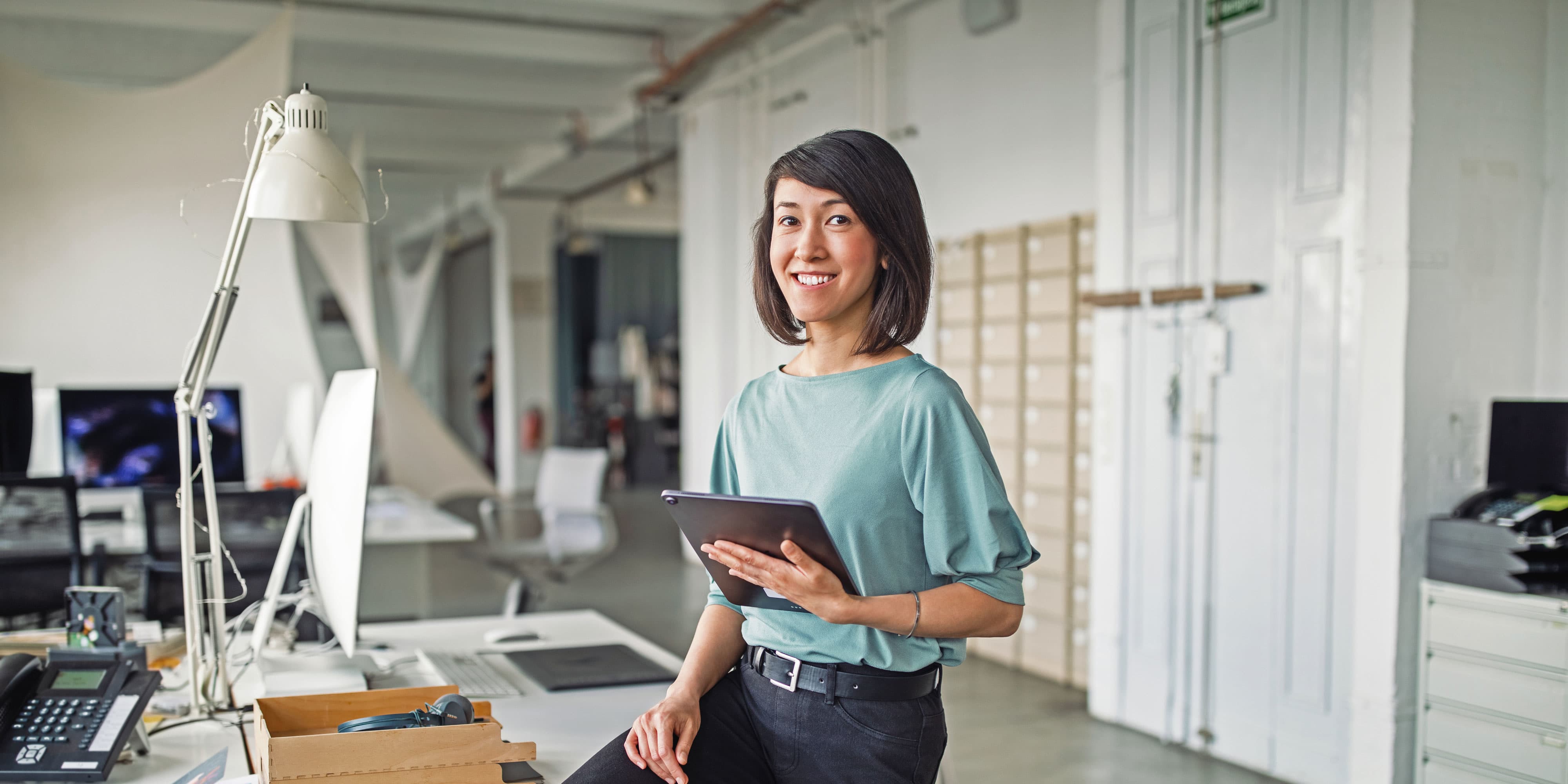 Titelbild für Infoseite “IU Leitbild zum Thema Diversity und Gleichstellung”: Frau mit Tablet im Büro