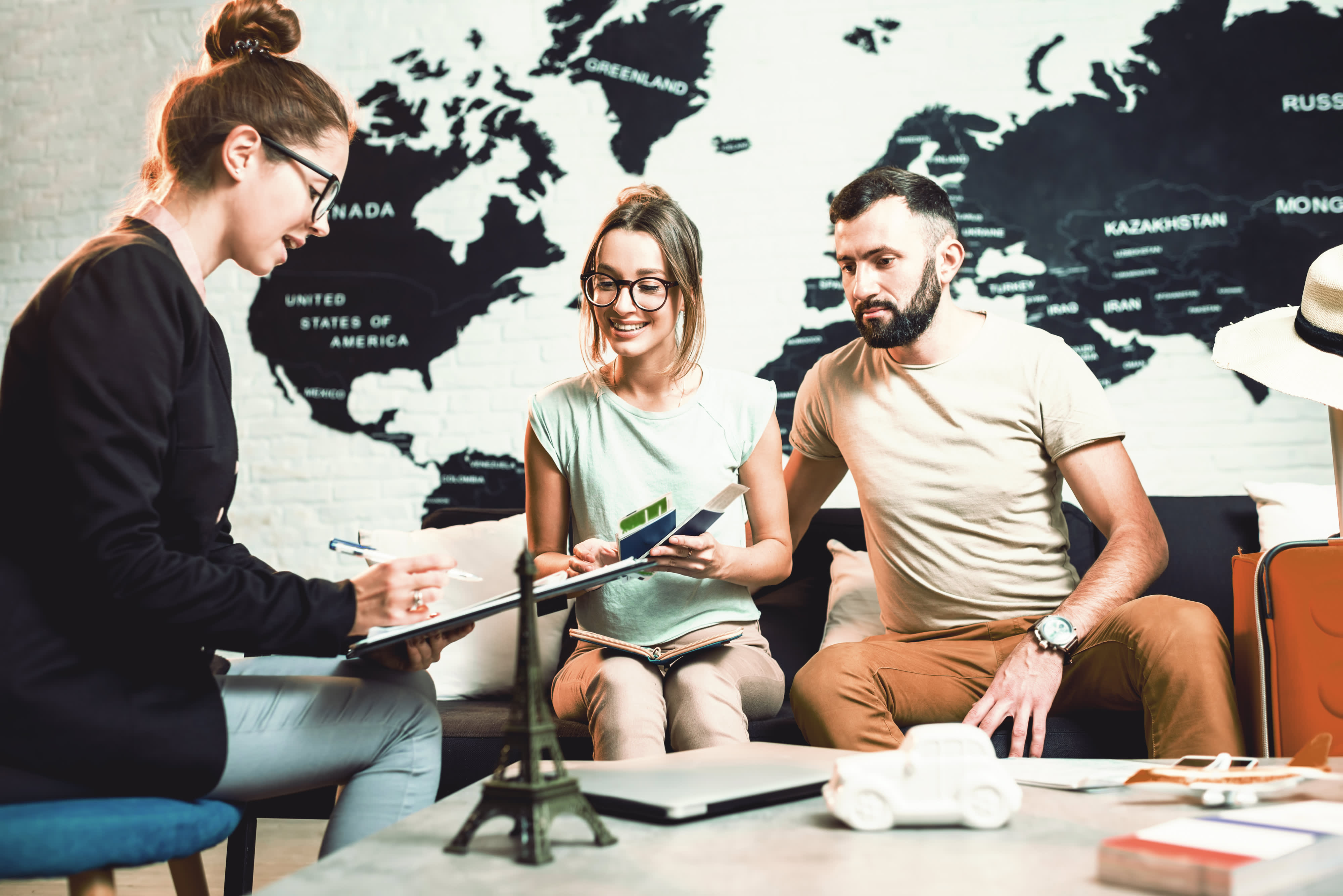 Frau berät Paar bei der Reiseplanung