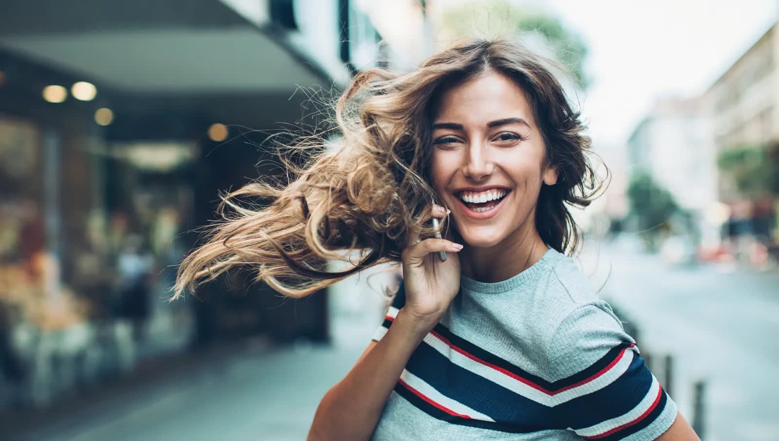 Titelbild für Infoseiten "Duales Studium Benefits": lachende Studentin am Handy