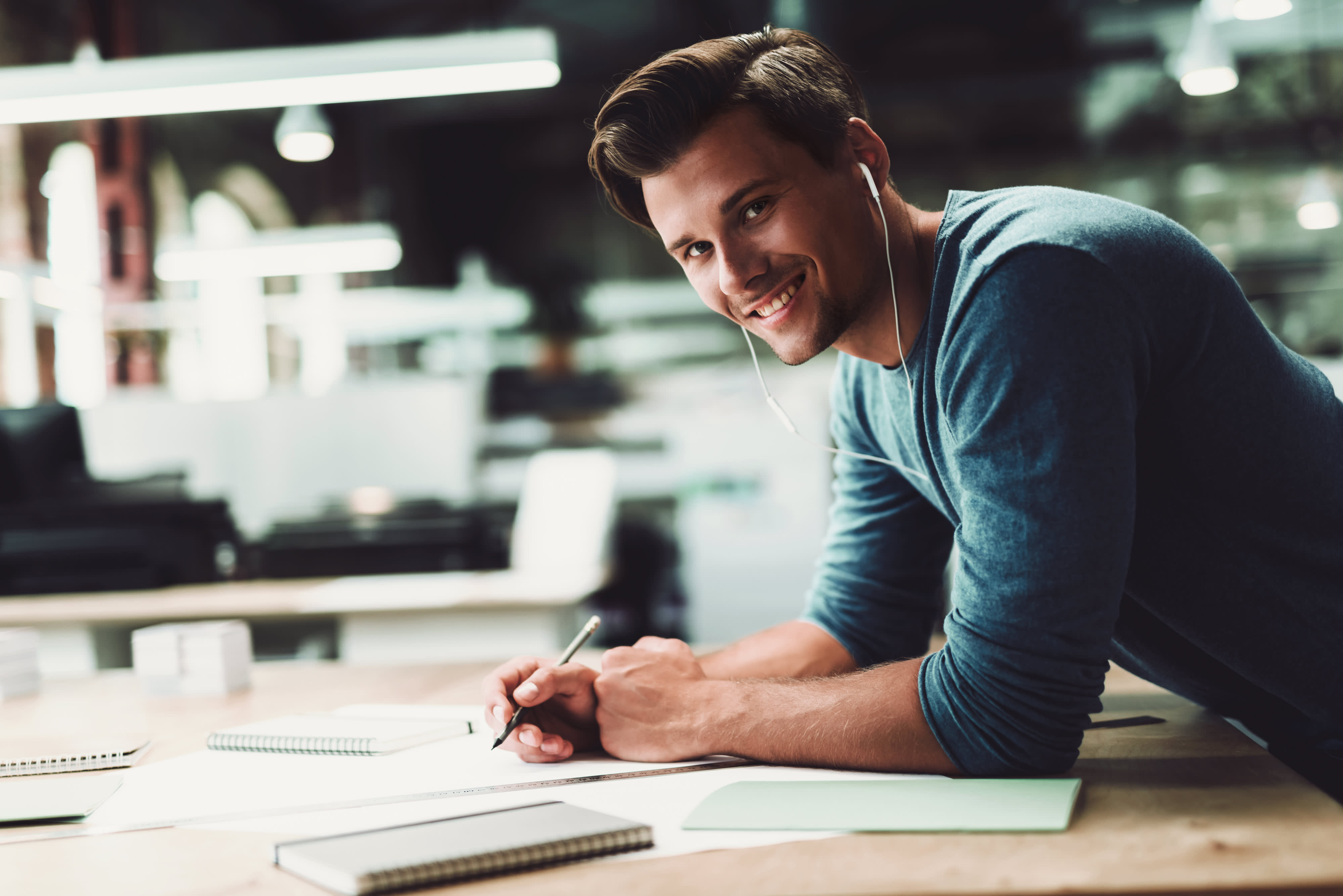 Titelbild für Infoseite “Bachelor Bauprojektmanagement”: Student arbeitet an Bauskizzen