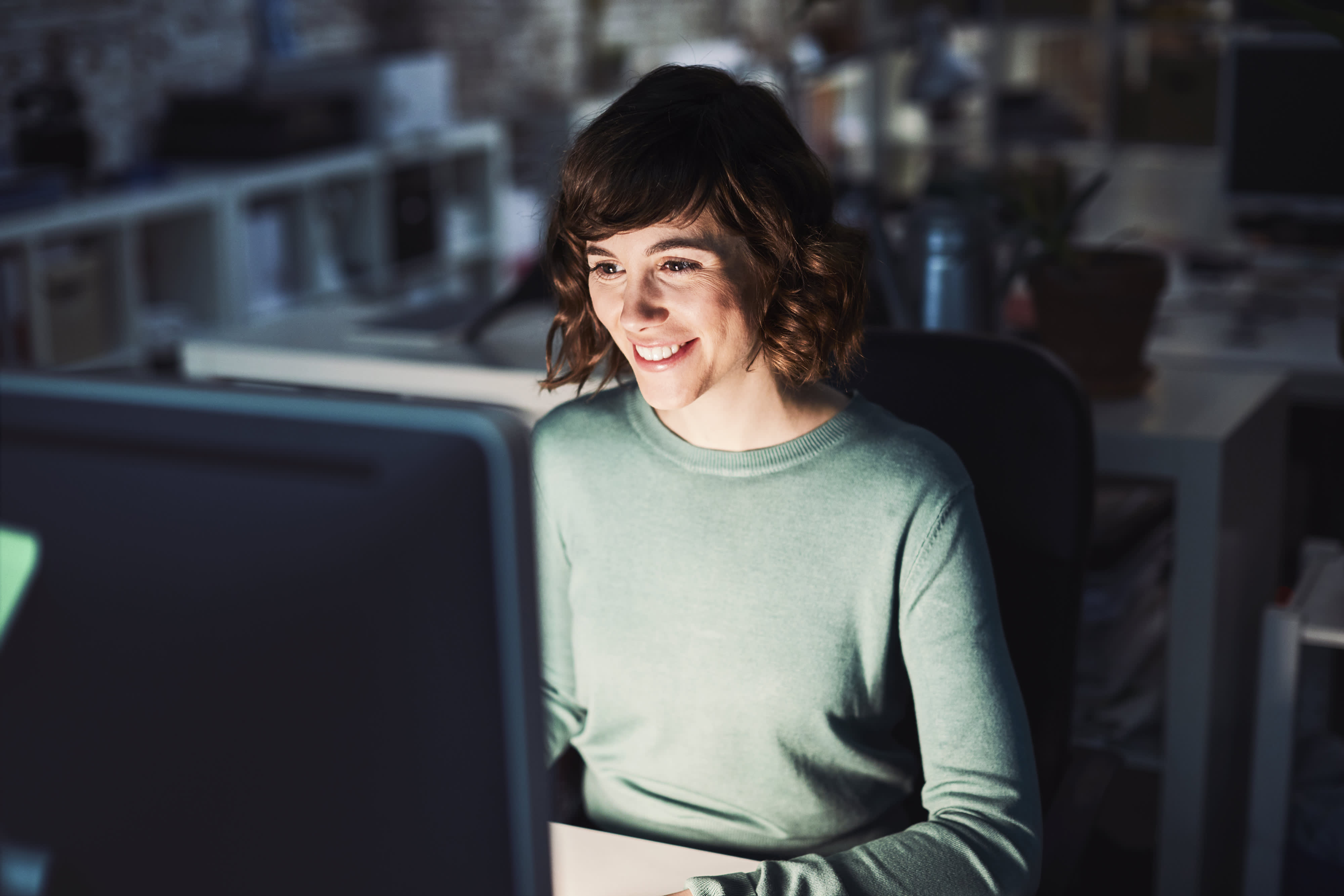 Titelbild für Infoseite “Master Digitale Transformation”: Digital Transformation Managerin arbeitet am Schreibtisch im Büro